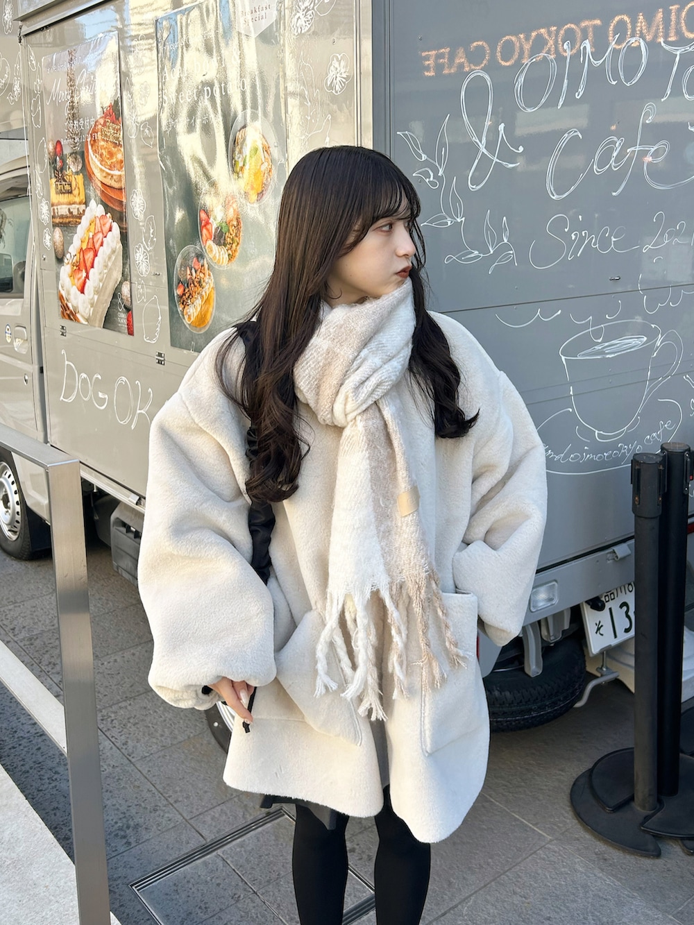 ブラック系のバッグ、ベージュ系のブーツ、ホワイト系のその他アウターを着用したレディースの冬コーディネートの3枚目の写真