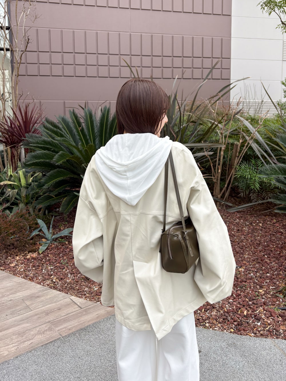 ホワイト系のスウェットパンツ、ピンク系のカーディガン/ボレロ、グリーン系のトートバッグを着用したレディースの春コーディネートの2枚目の写真