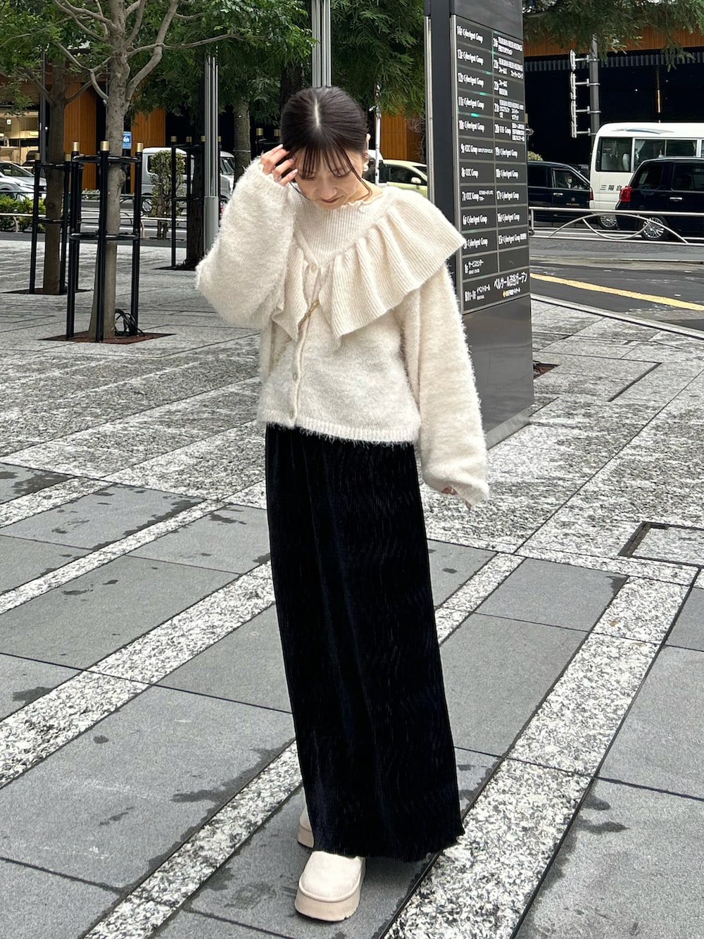 ブラック系のスカート、ホワイト系のショルダーバッグ、ホワイト系のニット/セーターを着用したレディースの冬コーディネートの2枚目の写真