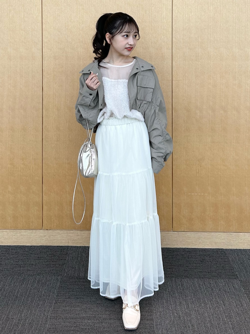 グリーン系のその他アウター、ベージュ系のシャツ/ブラウス、ホワイト系のスカートを着用したレディースの春コーディネートの2枚目の写真