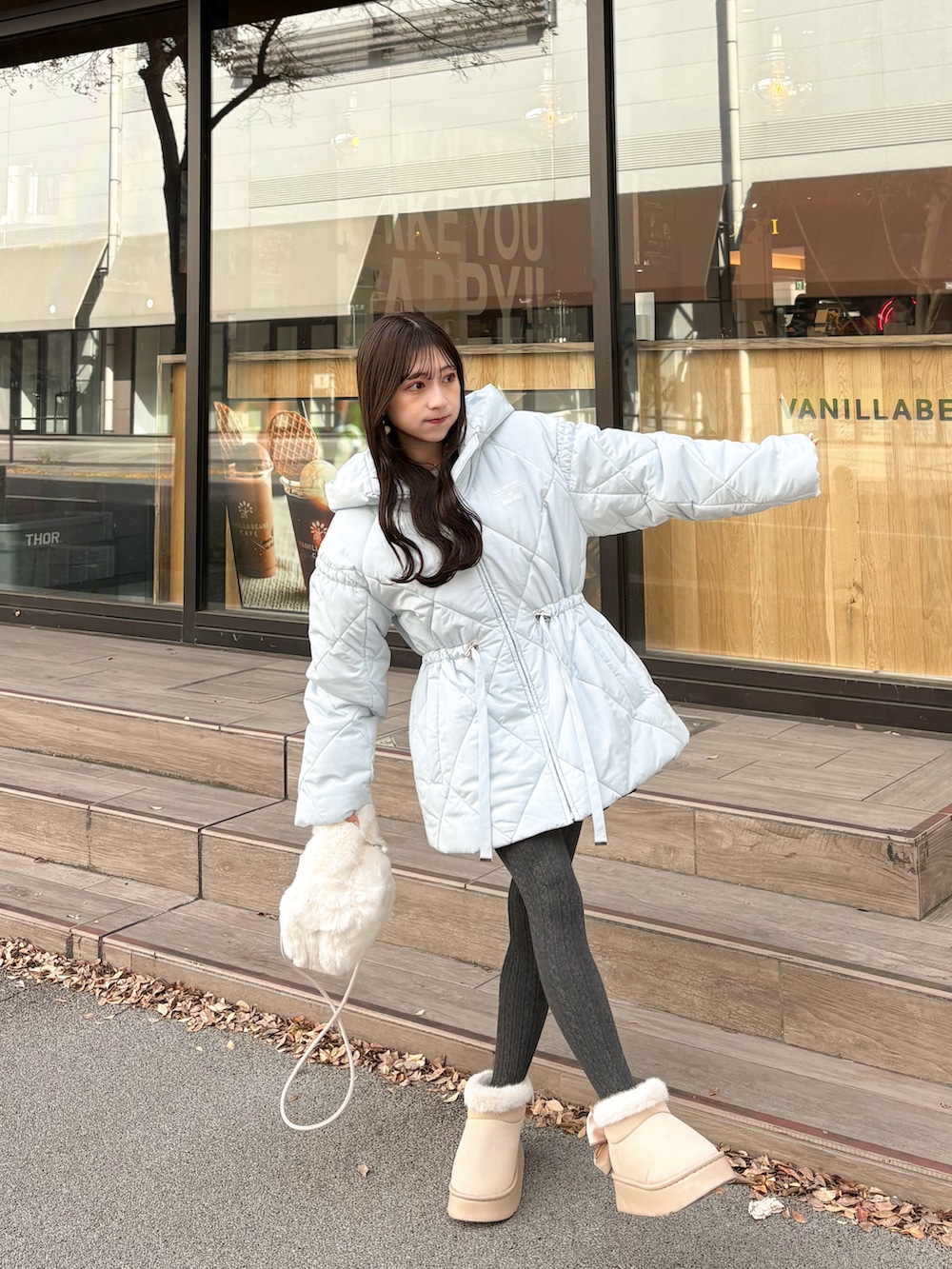 ブルー系のその他アウター、ホワイト系のハンドバッグ、ベージュ系のブーツを着用したレディースの秋コーディネートの3枚目の写真