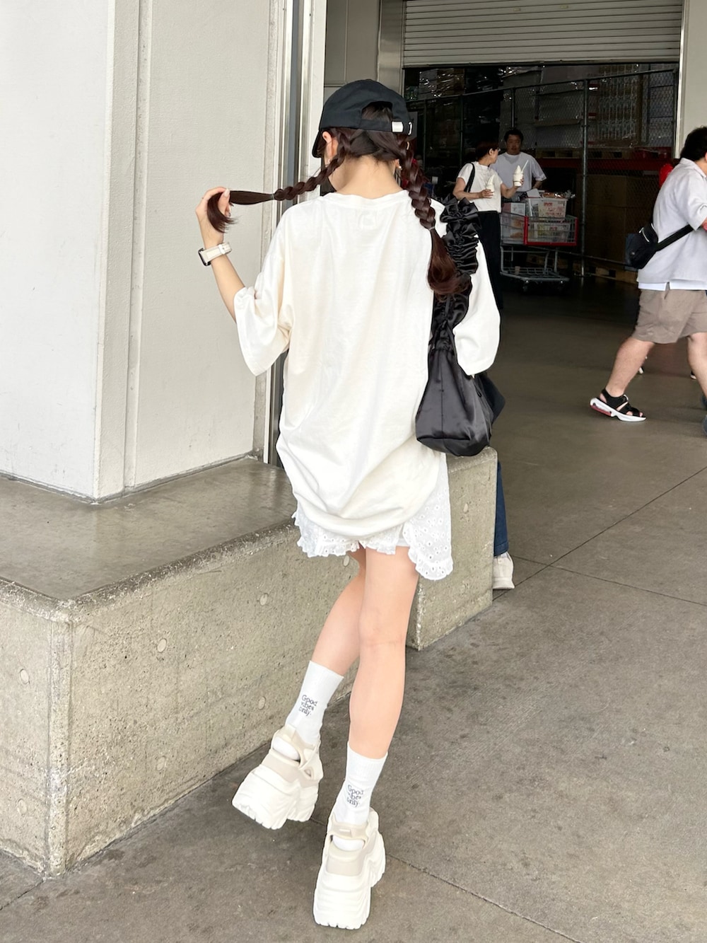 ホワイト系のサンダル、ホワイト系のチノパンツ、ホワイト系のTシャツ/カットソーを着用したレディースの夏コーディネートの3枚目の写真