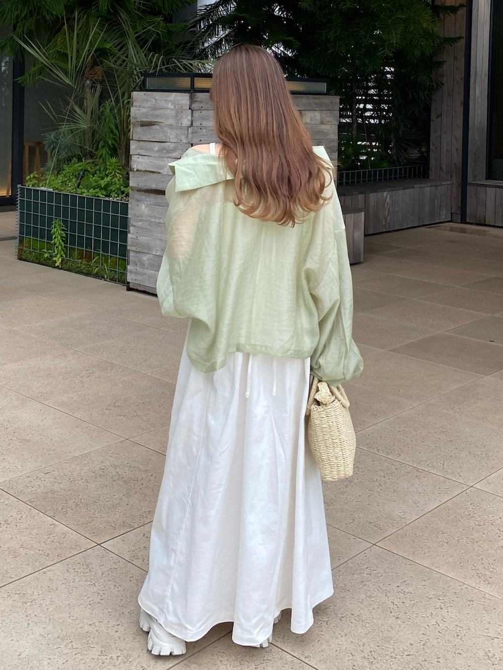 ホワイト系のワンピース、ベージュ系のかごバッグ、グリーン系のシャツ/ブラウスを着用したレディースの夏コーディネートの2枚目の写真