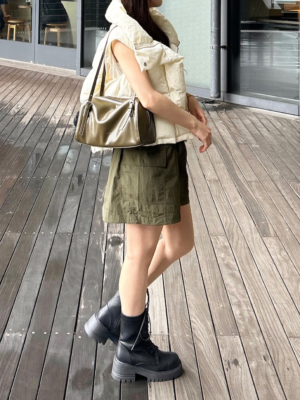 グリーン系のトートバッグ、グリーン系のスカート、ホワイト系のTシャツ/カットソーを着用したレディースの秋コーディネートの4枚目の写真