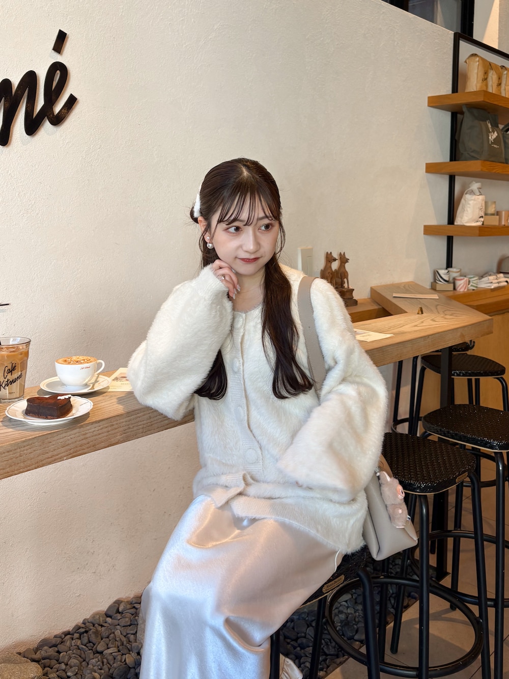 ホワイト系のスカート、ベージュ系のカーディガン/ボレロ、ブラウン系のパンプスを着用したレディースの冬コーディネートの4枚目の写真