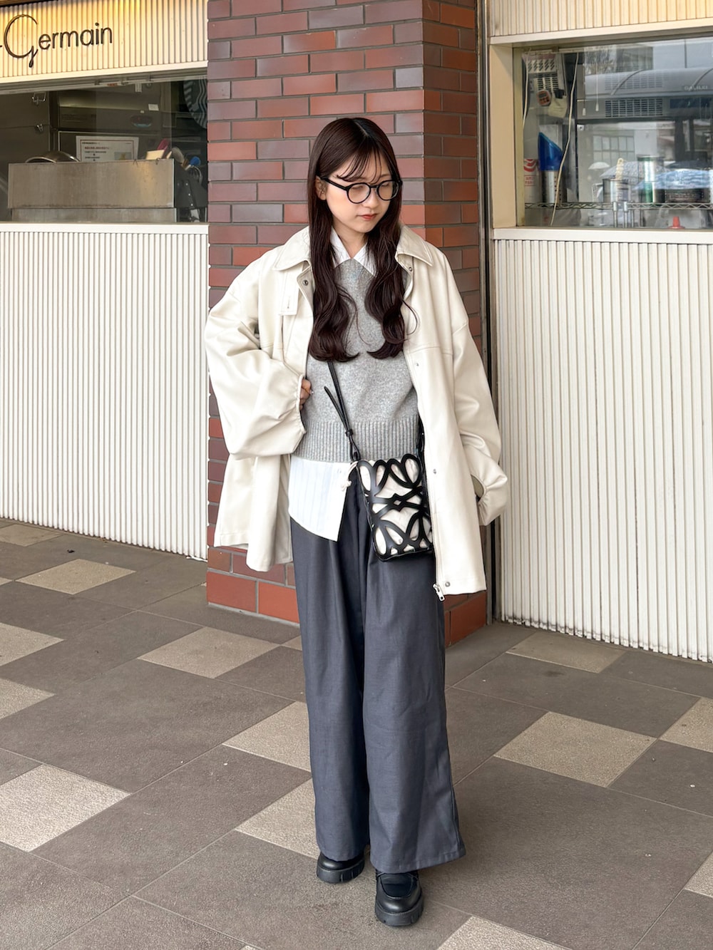 ブラック系のシューズ、グレー系のニット/セーター、ホワイト系のシャツ/ブラウスを着用したレディースの春コーディネートの2枚目の写真