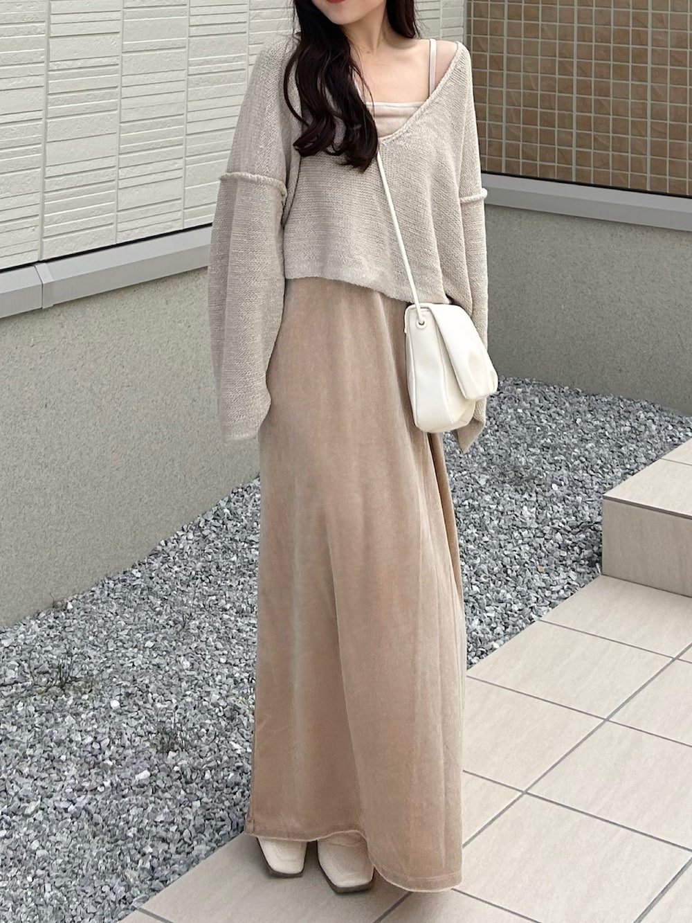 ホワイト系のショルダーバッグ、ベージュ系のニット/セーター、ホワイト系のワンピースを着用したレディースの秋コーディネートの3枚目の写真