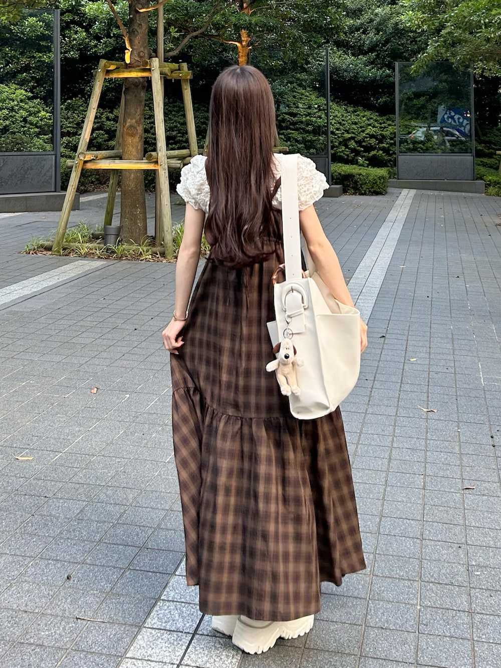 ブラウン系のワンピース、ホワイト系のトートバッグ、ホワイト系のサンダルを着用したレディースの夏コーディネートの3枚目の写真