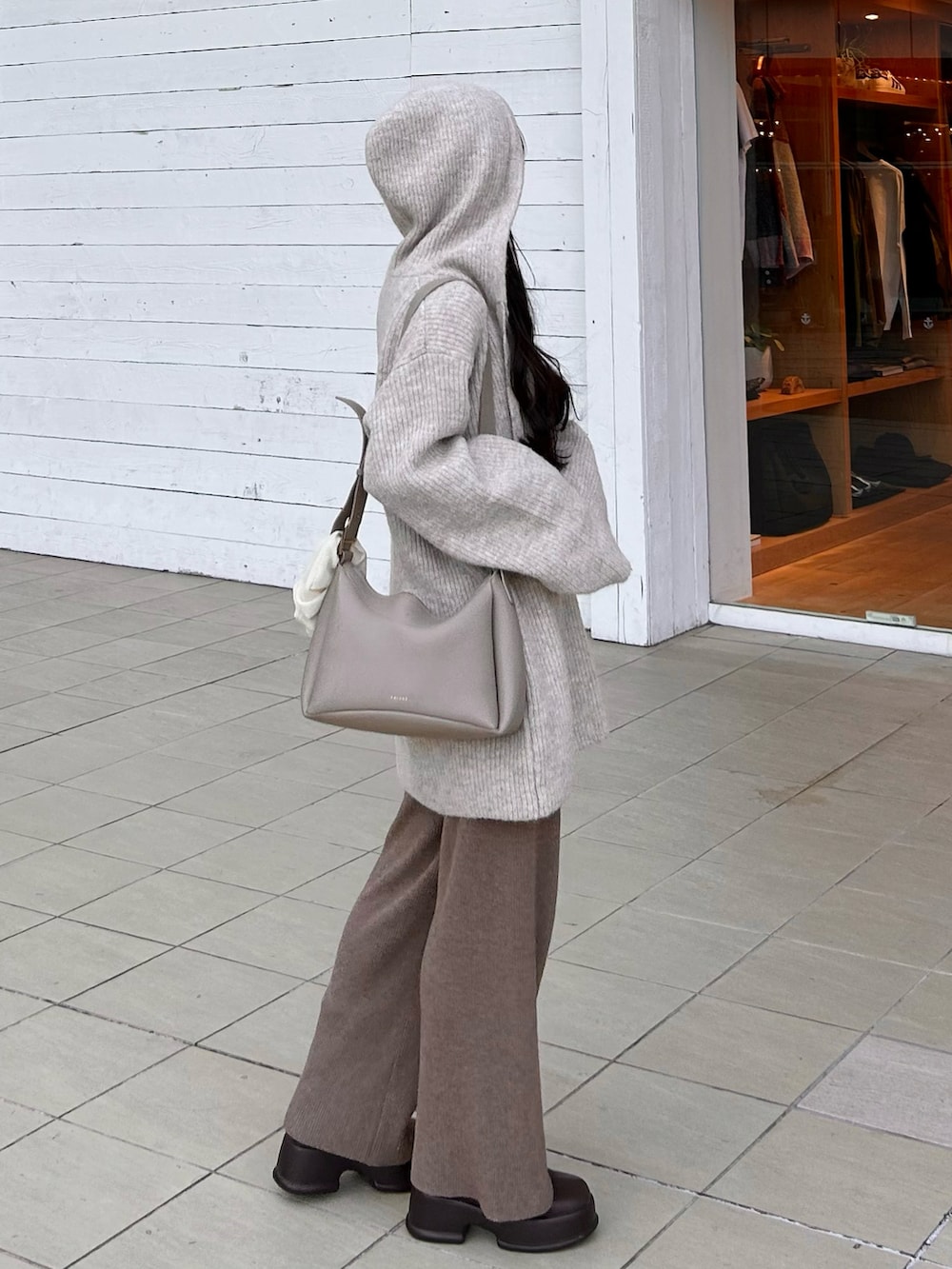 ブラウン系のブーツ、ブラウン系のパンツ、ベージュ系のバッグを着用したレディースの冬コーディネートの4枚目の写真