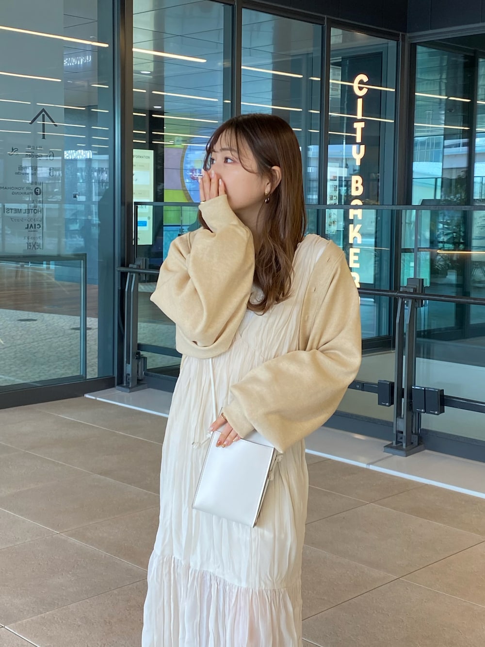 ホワイト系のワンピース、ホワイト系のカーディガン/ボレロ、ホワイト系のショルダーバッグを着用したレディースの春コーディネートの3枚目の写真