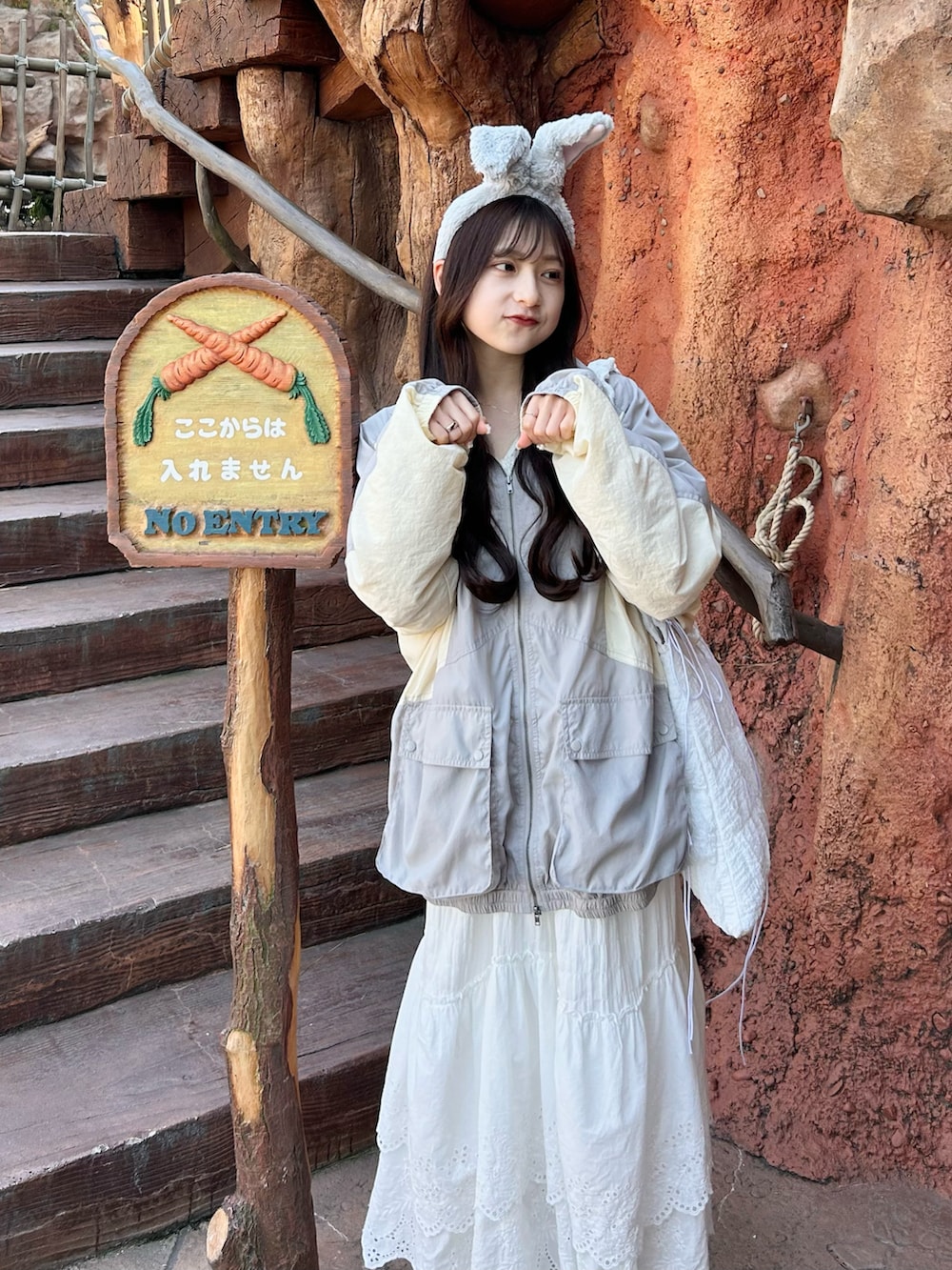 グレー系のナイロンジャケット、ホワイト系のスカート、ホワイト系のトートバッグを着用したレディースの春コーディネートの3枚目の写真