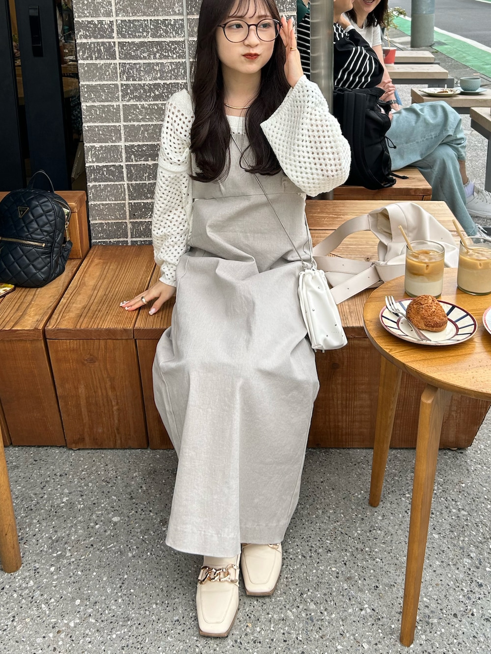 グレー系のワンピース、ホワイト系のショルダーバッグ、ホワイト系のローファーを着用したレディースの春コーディネートの3枚目の写真