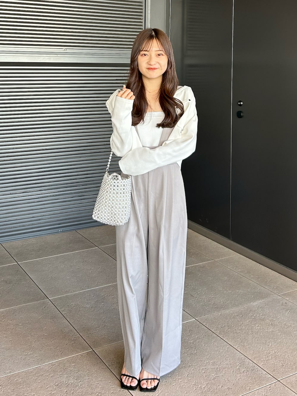 ホワイト系のキャミソール、グレー系のその他パンツ、シルバー系のバッグを着用したレディースの春コーディネートの2枚目の写真