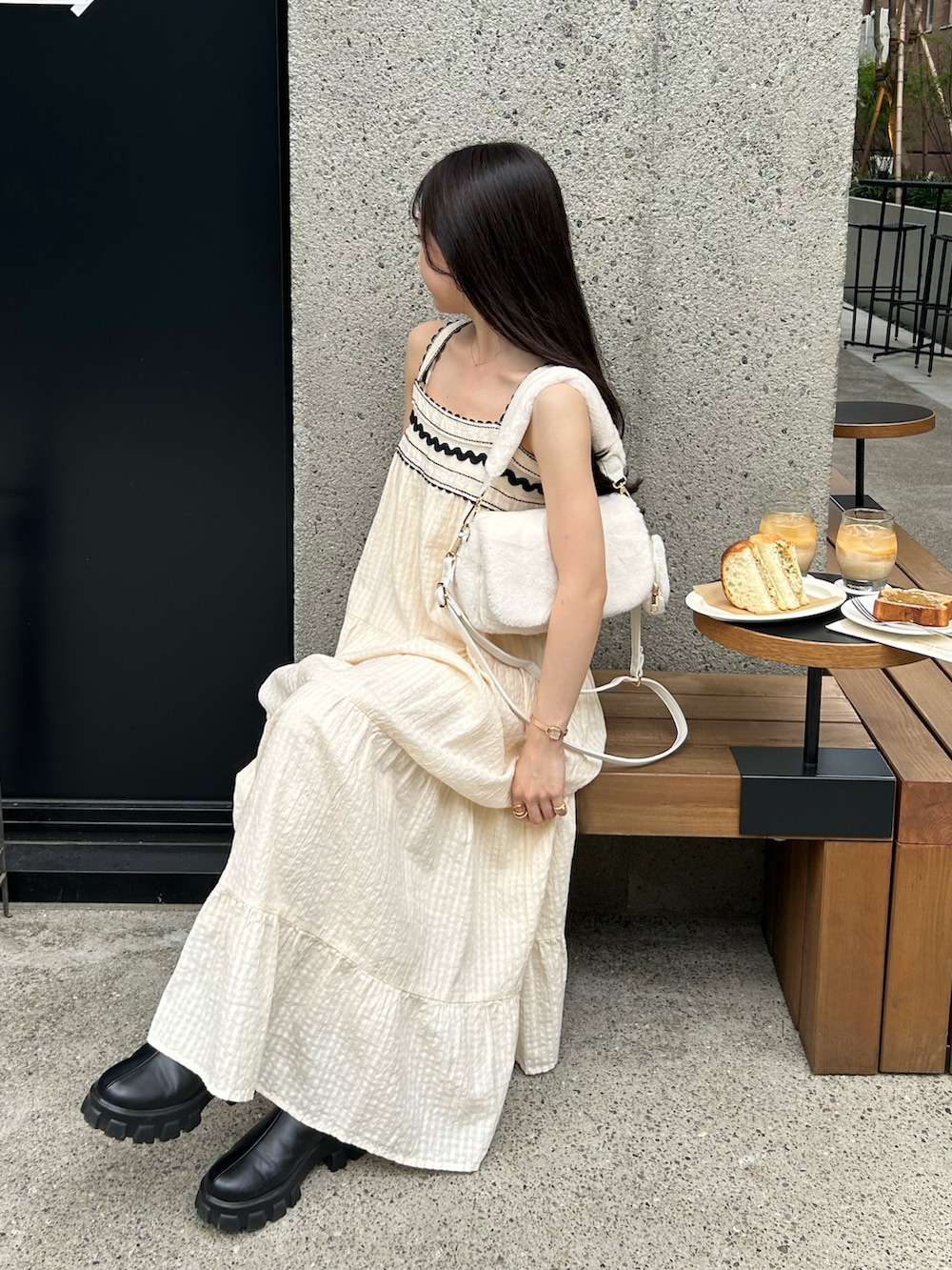 ホワイト系のワンピース/ドレス、ホワイト系のカーディガン/ボレロ、ホワイト系のショルダーバッグを着用したレディースの秋コーディネートの4枚目の写真