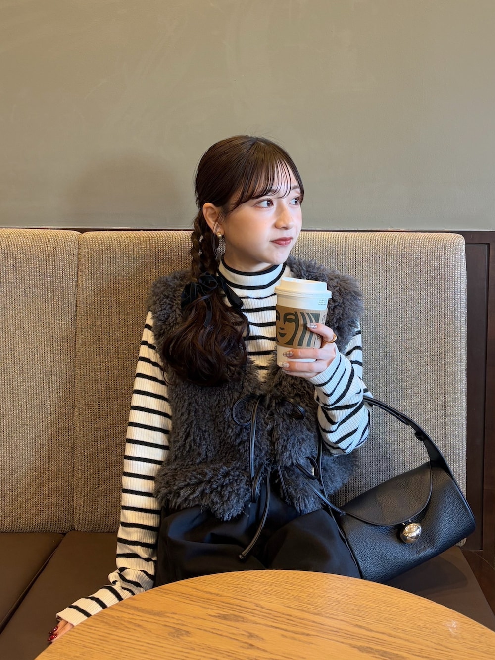 ブラック系のその他パンツ、ブラック系のバッグ、ホワイト系のニット/セーターを着用したレディースの冬コーディネートの3枚目の写真