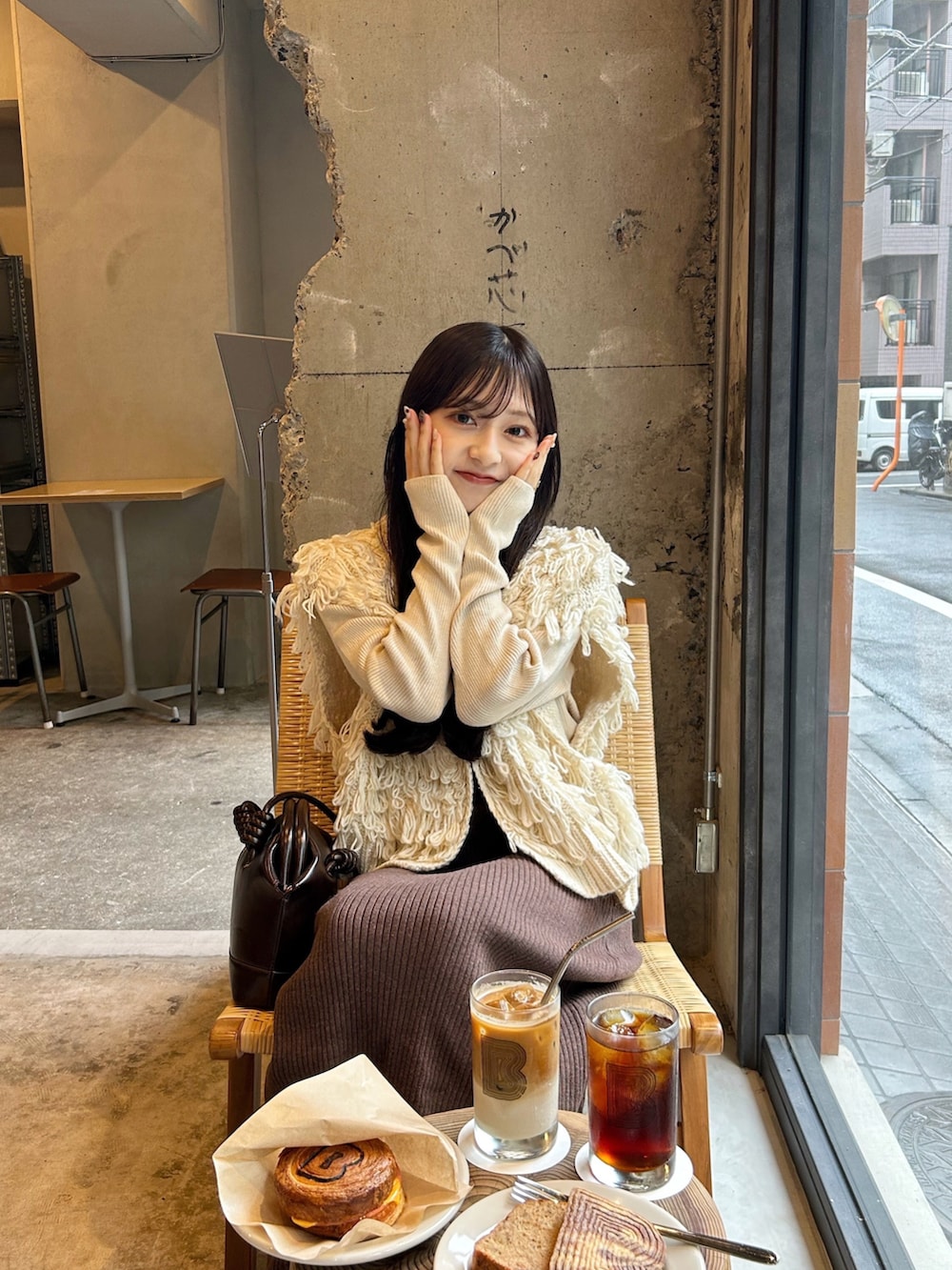 ブラウン系のスカート、ホワイト系のベスト、ホワイト系のニット/セーターを着用したレディースの秋コーディネートの4枚目の写真