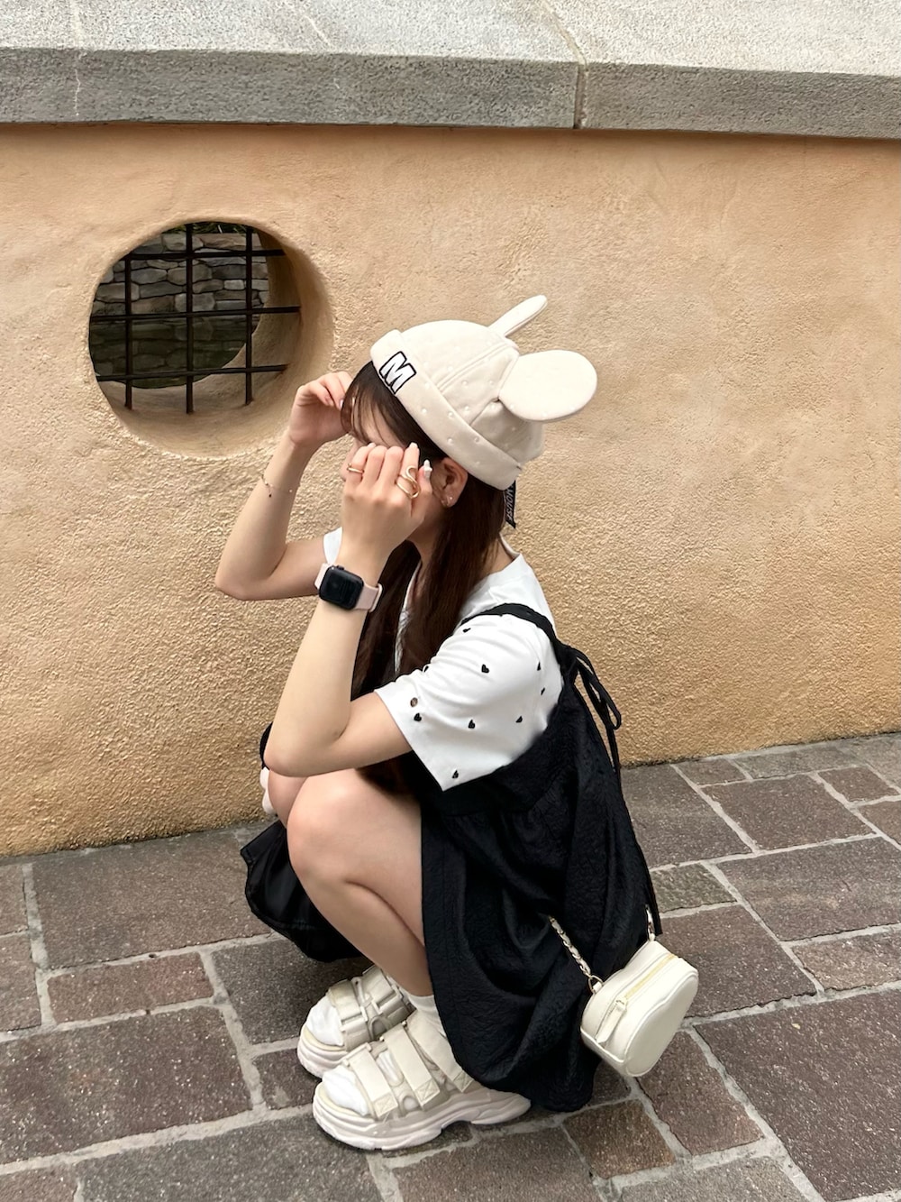 ブラック系のトートバッグ、ブラック系のキャミソール、ホワイト系のサンダルを着用したレディースの夏コーディネートの4枚目の写真