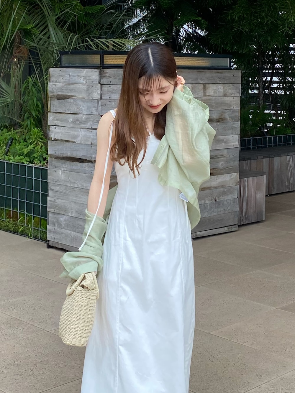 ホワイト系のワンピース、ベージュ系のかごバッグ、グリーン系のシャツ/ブラウスを着用したレディースの夏コーディネートの5枚目の写真