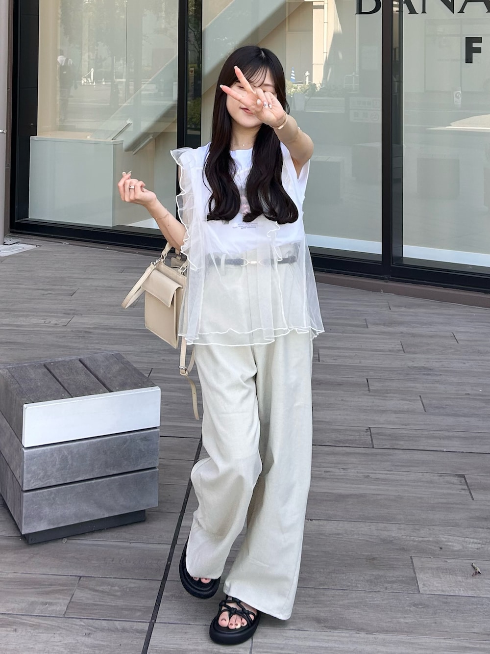 ベージュ系のハンドバッグ、ホワイト系のベスト、ホワイト系のTシャツ/カットソーを着用したレディースの夏コーディネートの2枚目の写真