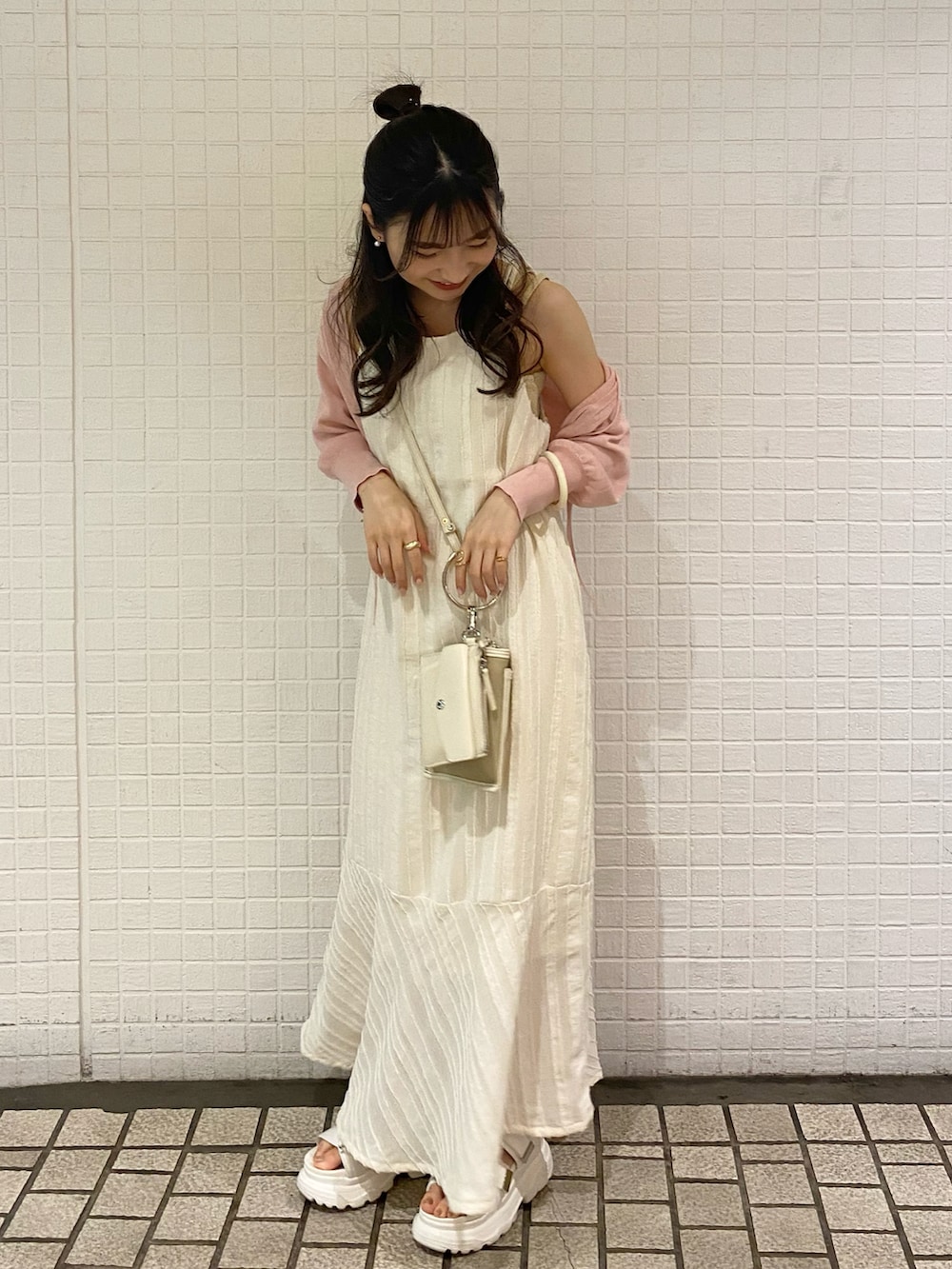 ホワイト系のワンピース、ホワイト系のサンダル、ベージュ系のショルダーバッグを着用したレディースの夏コーディネートの3枚目の写真