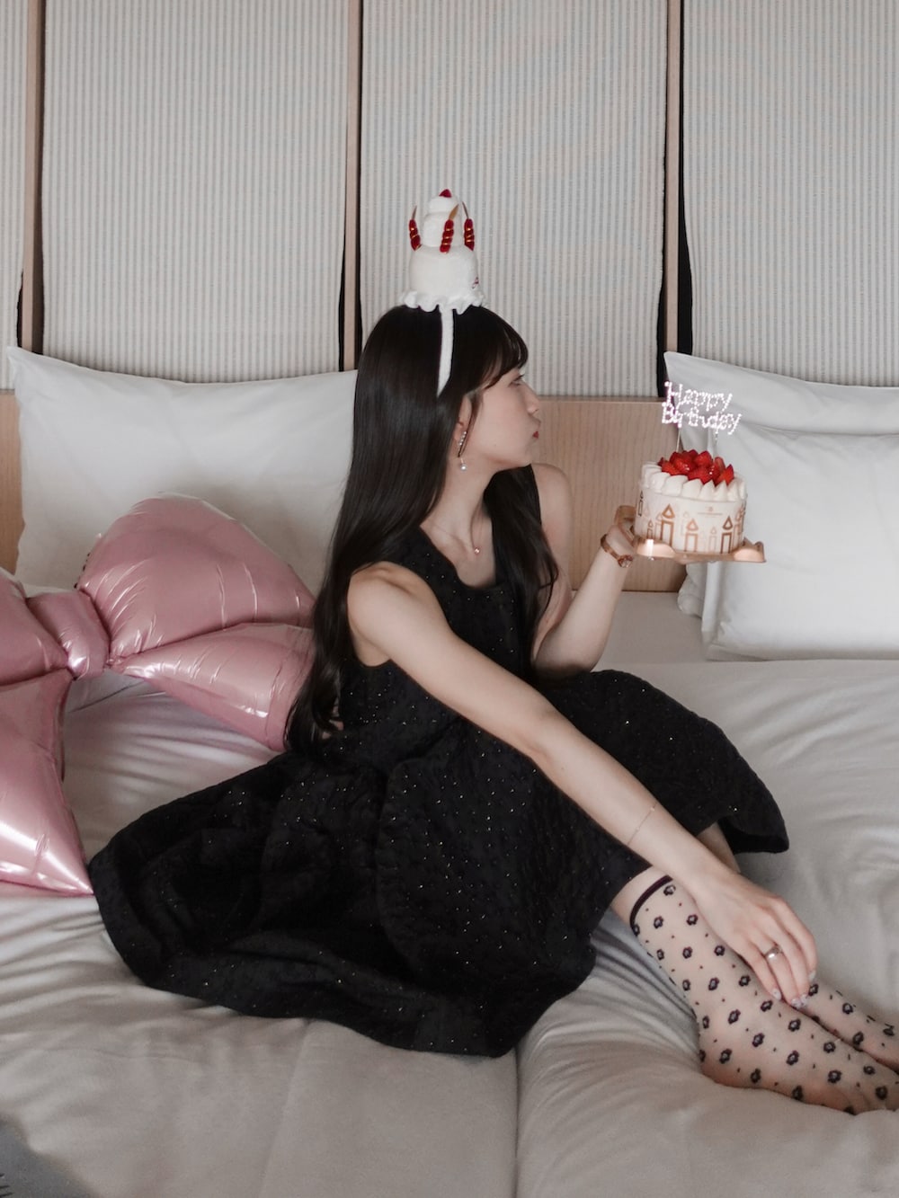 ホワイト系のパンプス、ホワイト系のハンドバッグ、ブラック系のドレスを着用したレディースの夏コーディネートの2枚目の写真