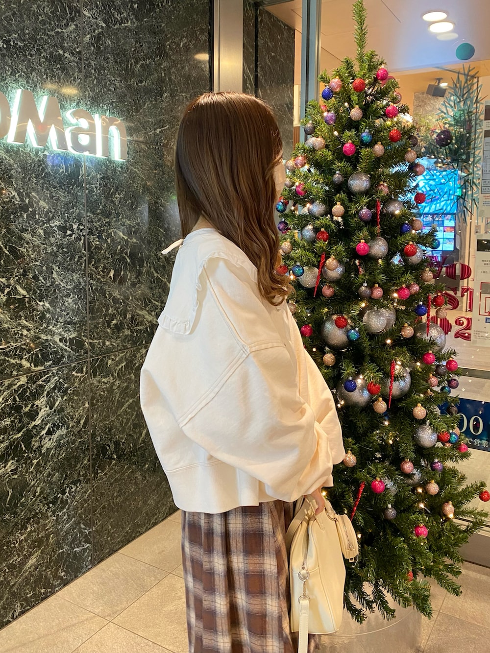 ブラウン系のスカート、ホワイト系のジャケット/アウター、ホワイト系のスウェットを着用したレディースの冬コーディネートの2枚目の写真