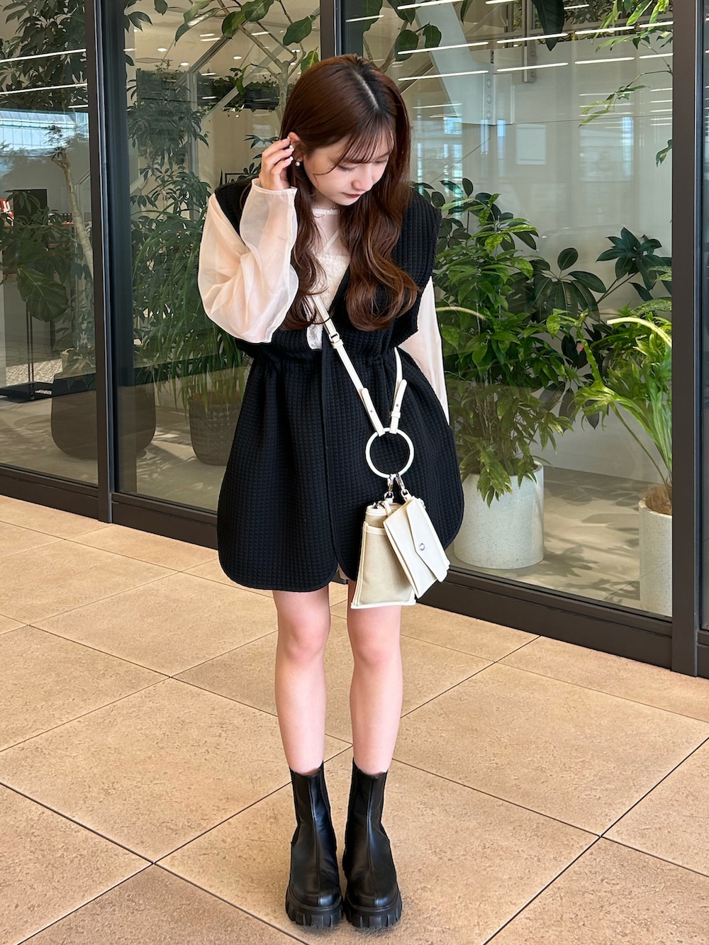 ブラック系のベスト、ベージュ系のシャツ/ブラウス、ベージュ系のショルダーバッグを着用したレディースの春コーディネートの4枚目の写真