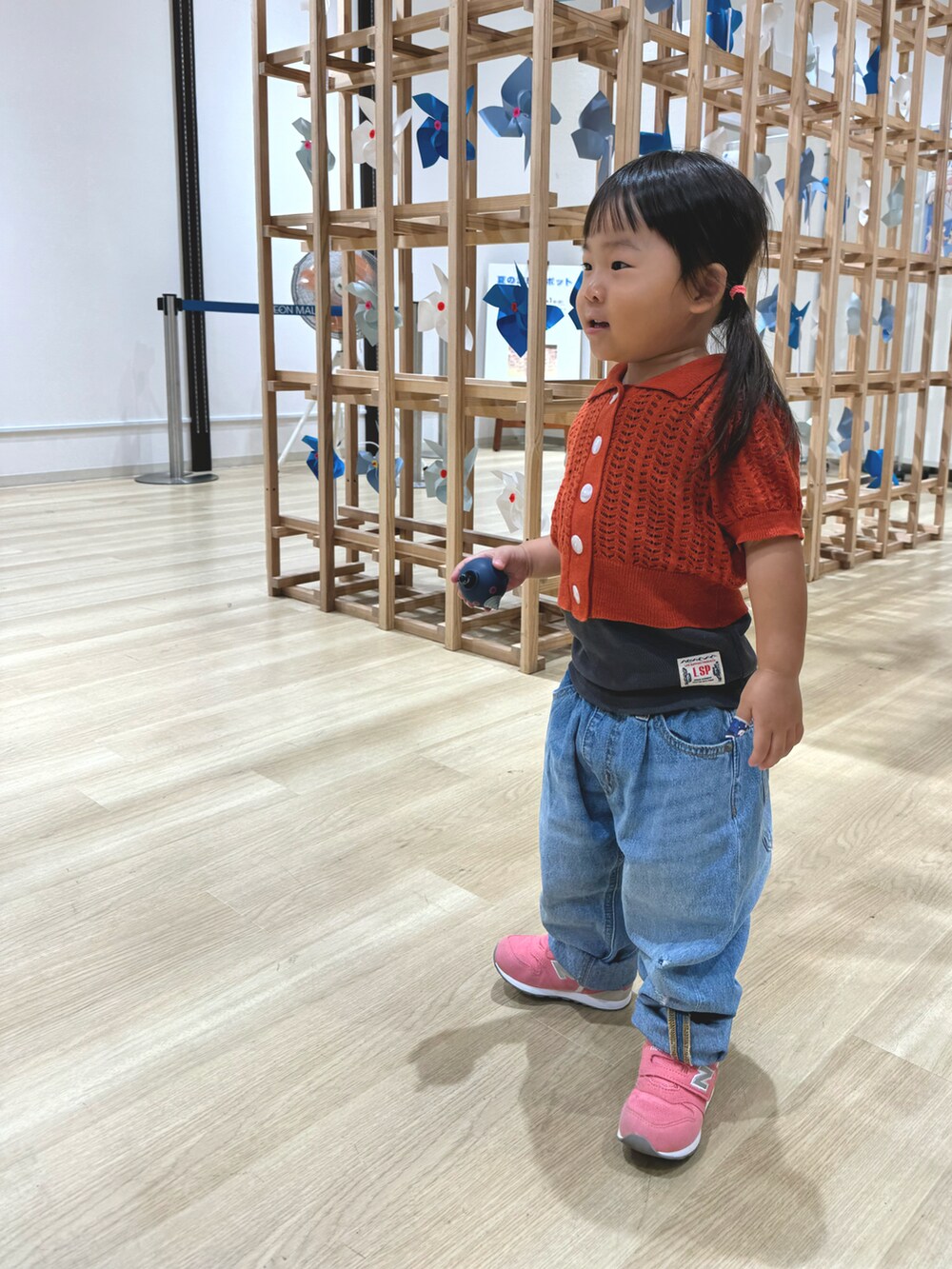 レッド系のトップス、グレー系のタンクトップ、ブルー系のデニムパンツを着用したキッズの夏コーディネートの2枚目の写真