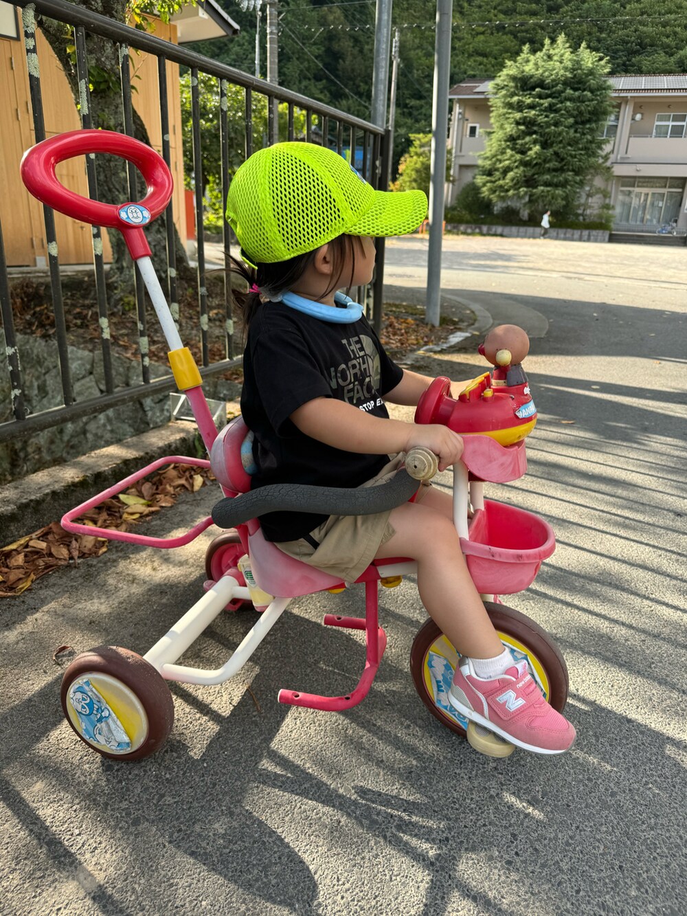 ブラック系のTシャツ/カットソー、ベージュ系のスカート、ピンク系のスニーカーを着用したキッズの夏コーディネートの2枚目の写真
