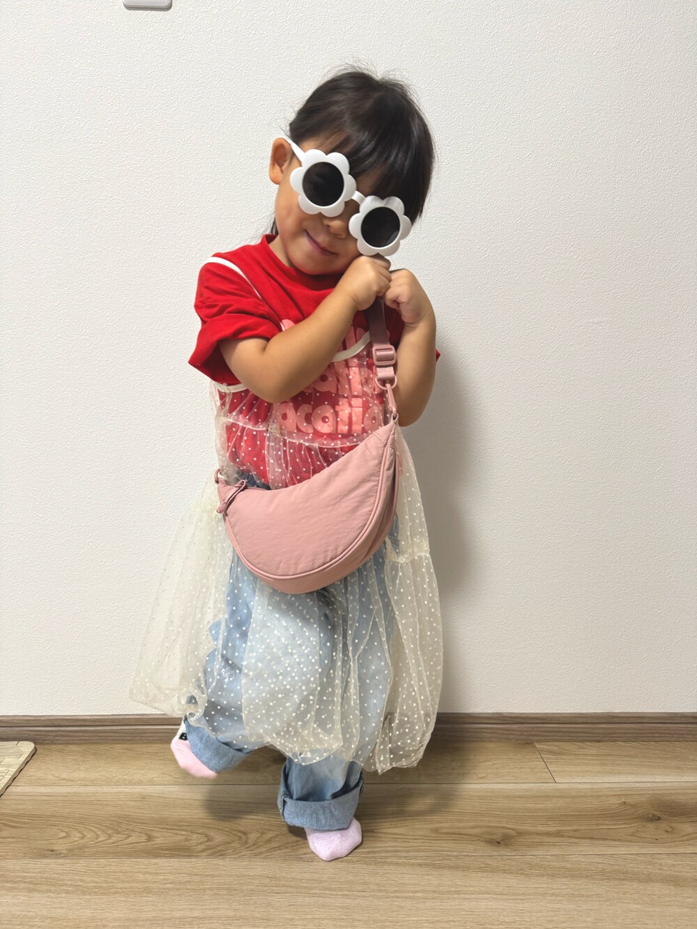 レッド系のTシャツ/カットソー、ホワイト系のワンピース、ブルー系のデニムパンツを着用したキッズの夏コーディネートの2枚目の写真