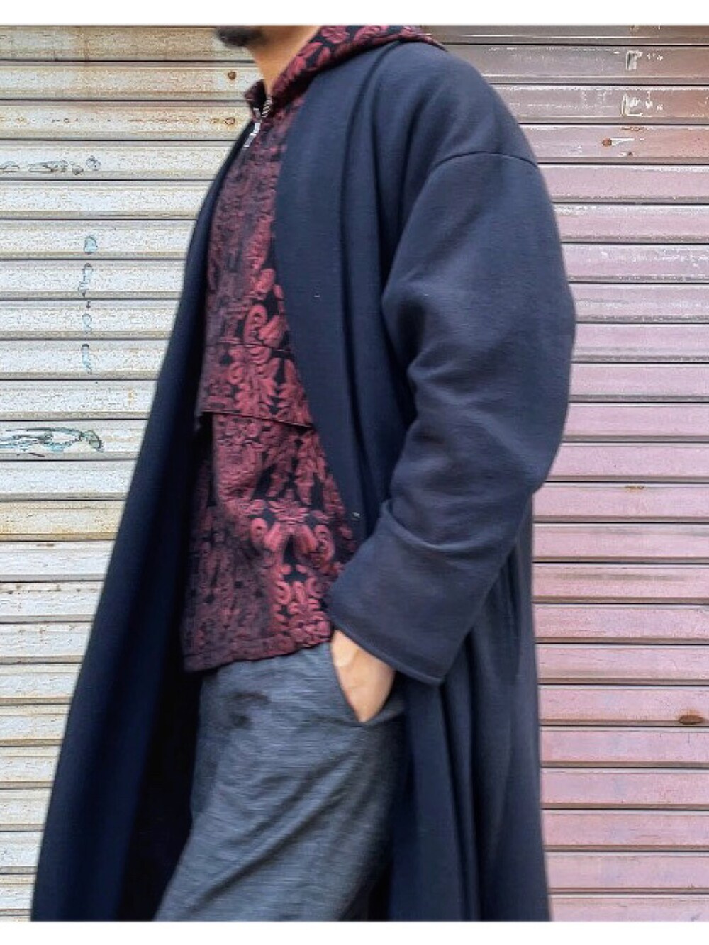 レッド系のパーカー、グレー系のスラックス、ブラック系のその他アウターを着用したメンズの冬コーディネートの3枚目の写真