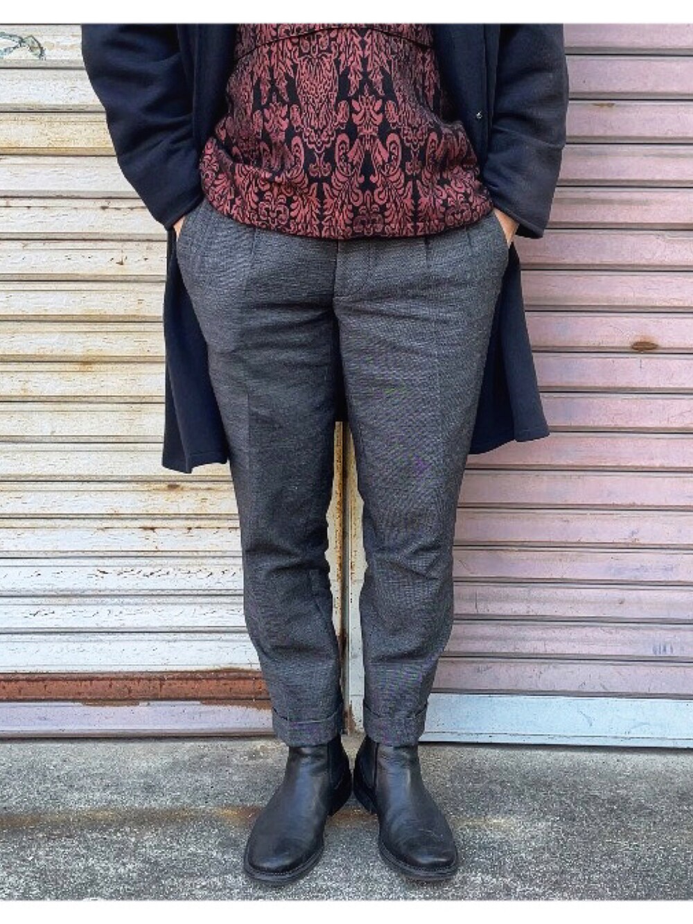 レッド系のパーカー、グレー系のスラックス、ブラック系のその他アウターを着用したメンズの冬コーディネートの4枚目の写真