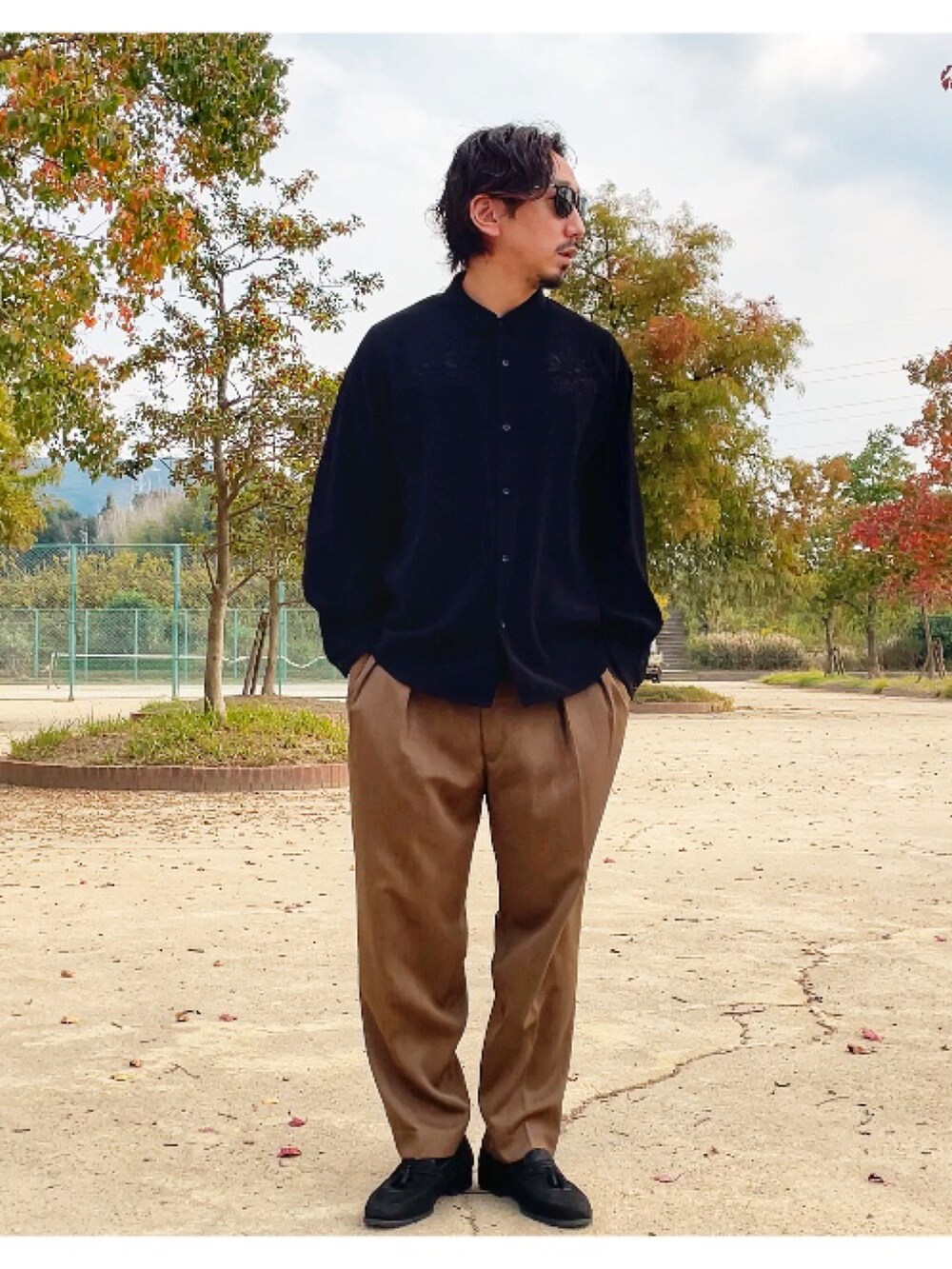 ブラック系のシャツ/ブラウス、グリーン系のスラックスを着用したメンズの秋コーディネートの2枚目の写真