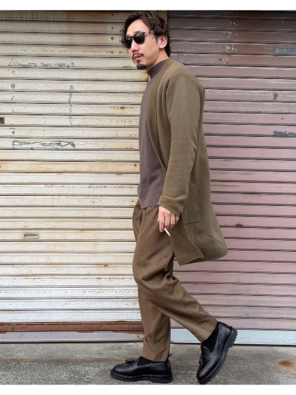 ブラウン系のニット/セーター、グリーン系のスラックス、グリーン系のカーディガン/ボレロを着用したメンズの冬コーディネートの3枚目の写真