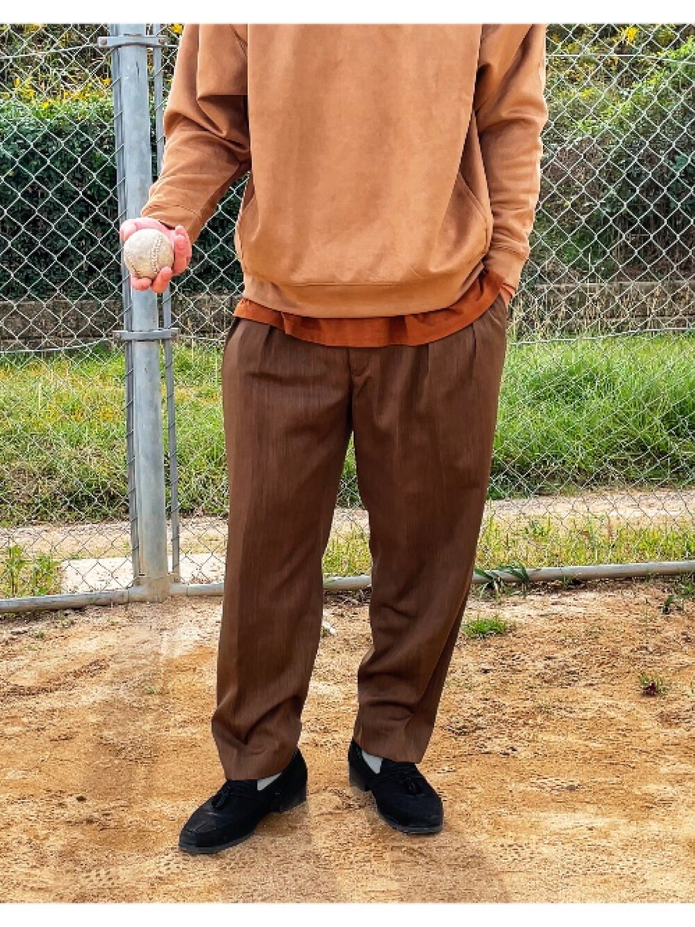 ブラウン系のTシャツ/カットソー、グリーン系のスラックスを着用したメンズの秋コーディネートの3枚目の写真