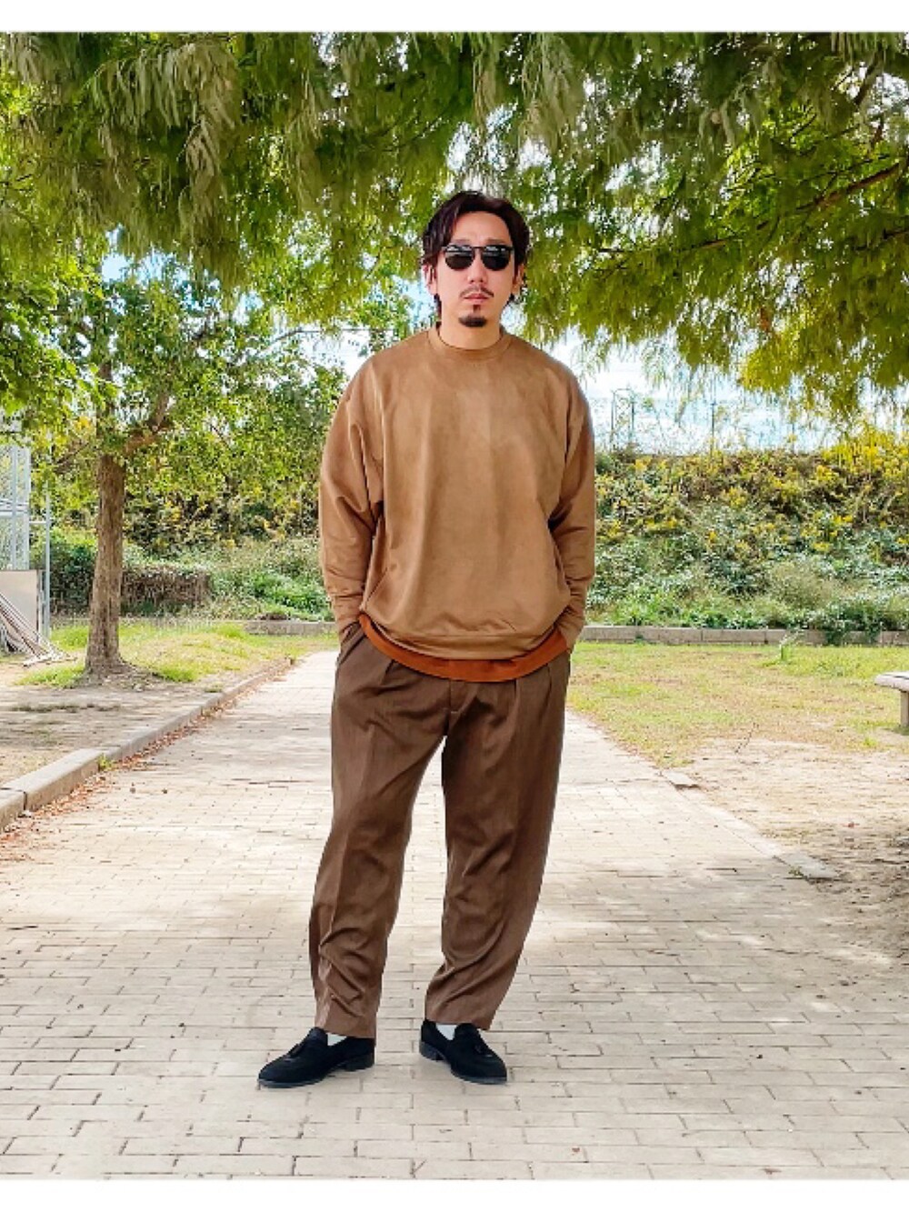 ブラウン系のTシャツ/カットソー、グリーン系のスラックスを着用したメンズの秋コーディネートの4枚目の写真