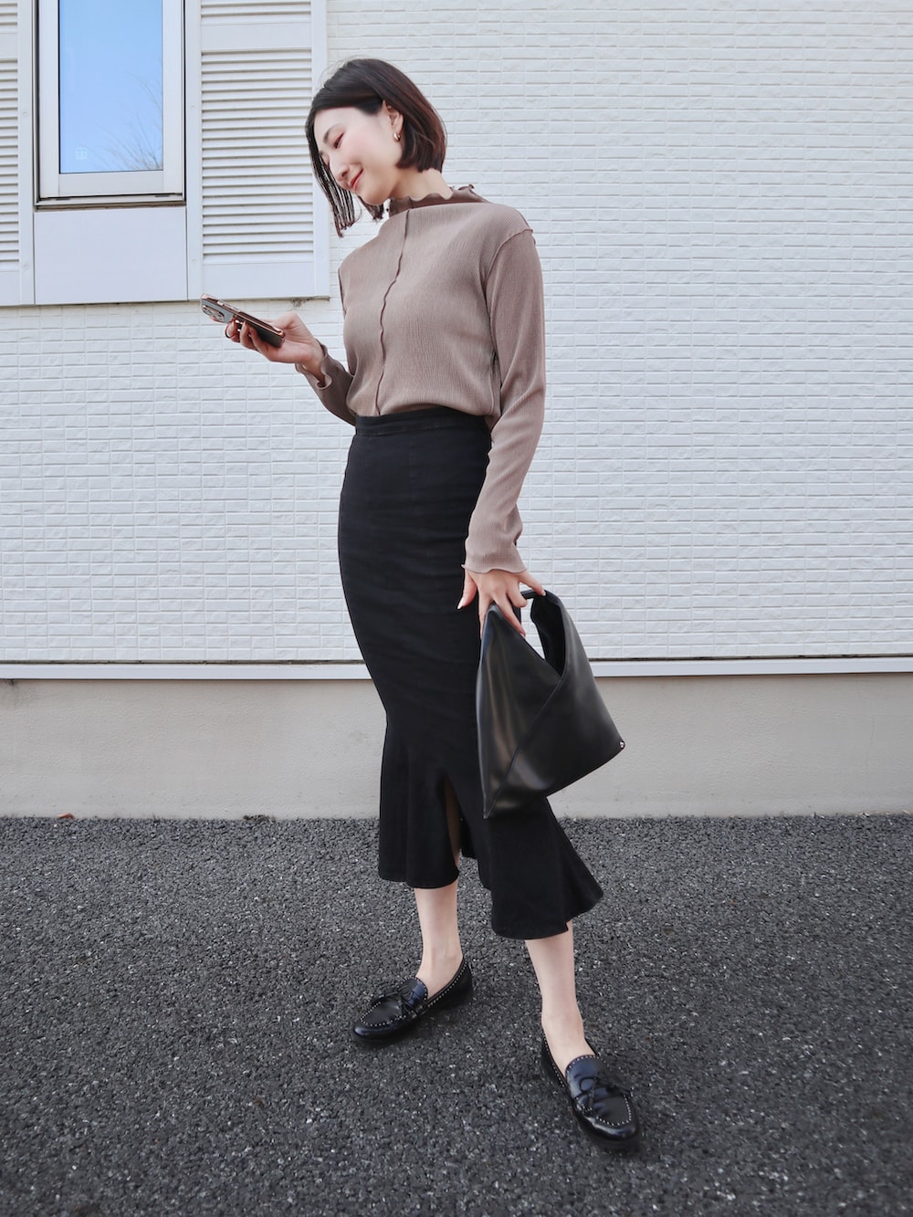 ブラウン系のTシャツ/カットソー、ブラック系のローファー、ブラック系のデニムスカートを着用したレディースの春コーディネートの3枚目の写真