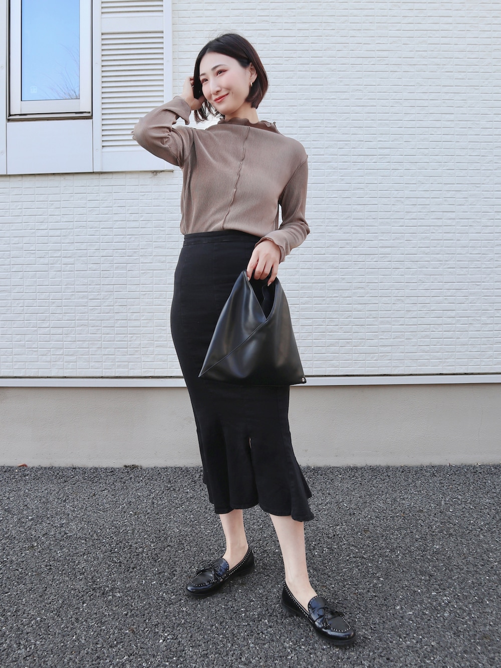 ブラウン系のTシャツ/カットソー、ブラック系のローファー、ブラック系のデニムスカートを着用したレディースの春コーディネートの2枚目の写真