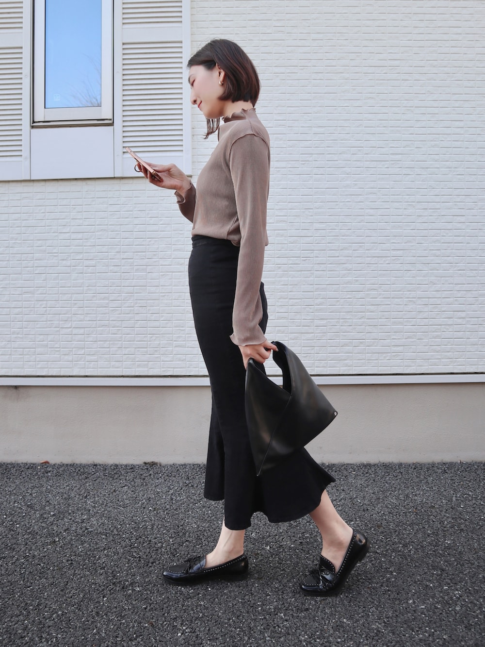 ブラウン系のTシャツ/カットソー、ブラック系のローファー、ブラック系のデニムスカートを着用したレディースの春コーディネートの4枚目の写真