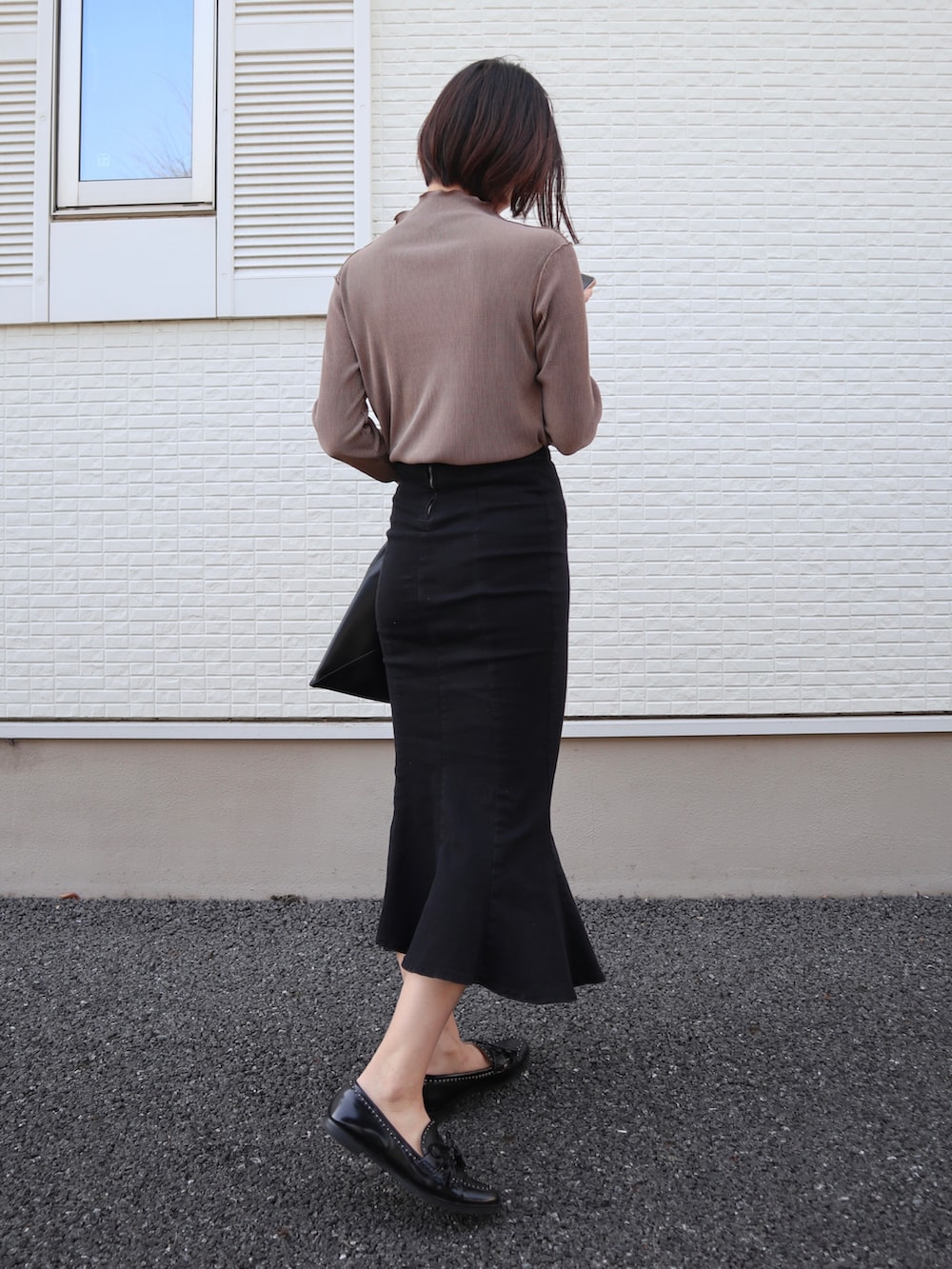 ブラウン系のTシャツ/カットソー、ブラック系のローファー、ブラック系のデニムスカートを着用したレディースの春コーディネートの5枚目の写真