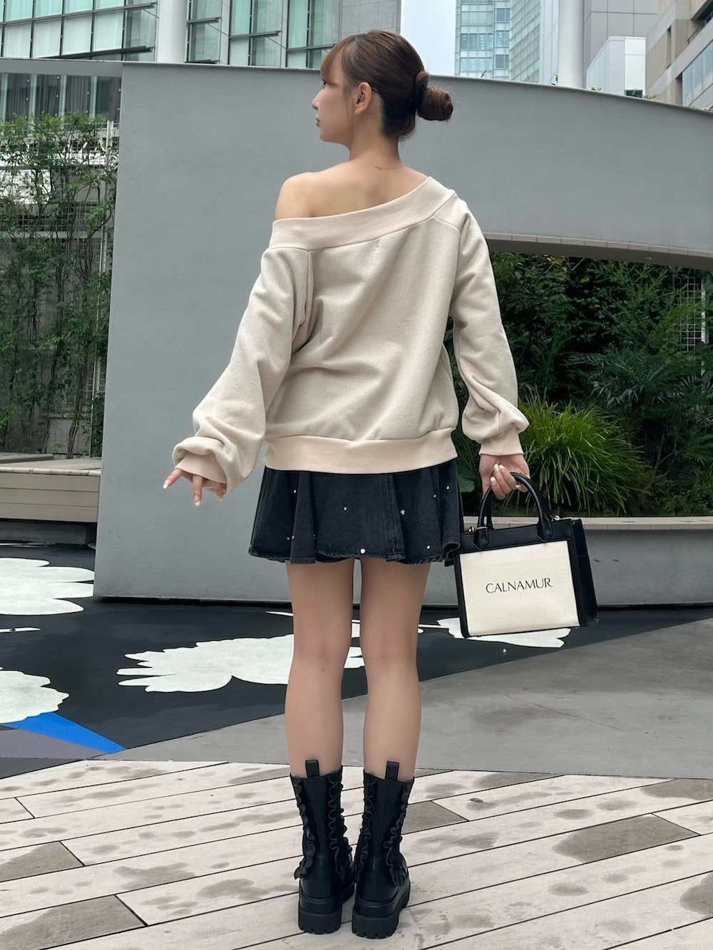 ブルー系のスカート、ベージュ系のスウェット、ホワイト系のブーツを着用したレディースの秋コーディネートの4枚目の写真