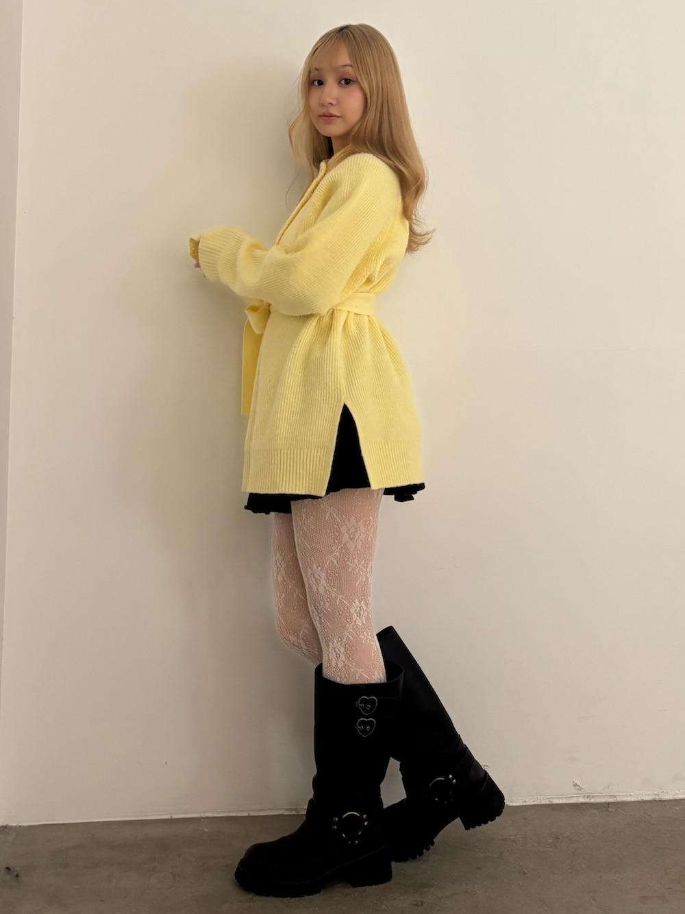 イエロー系のニット/セーター、ブラック系のその他パンツ、ブラック系のブーツを着用したレディースの秋コーディネートの4枚目の写真