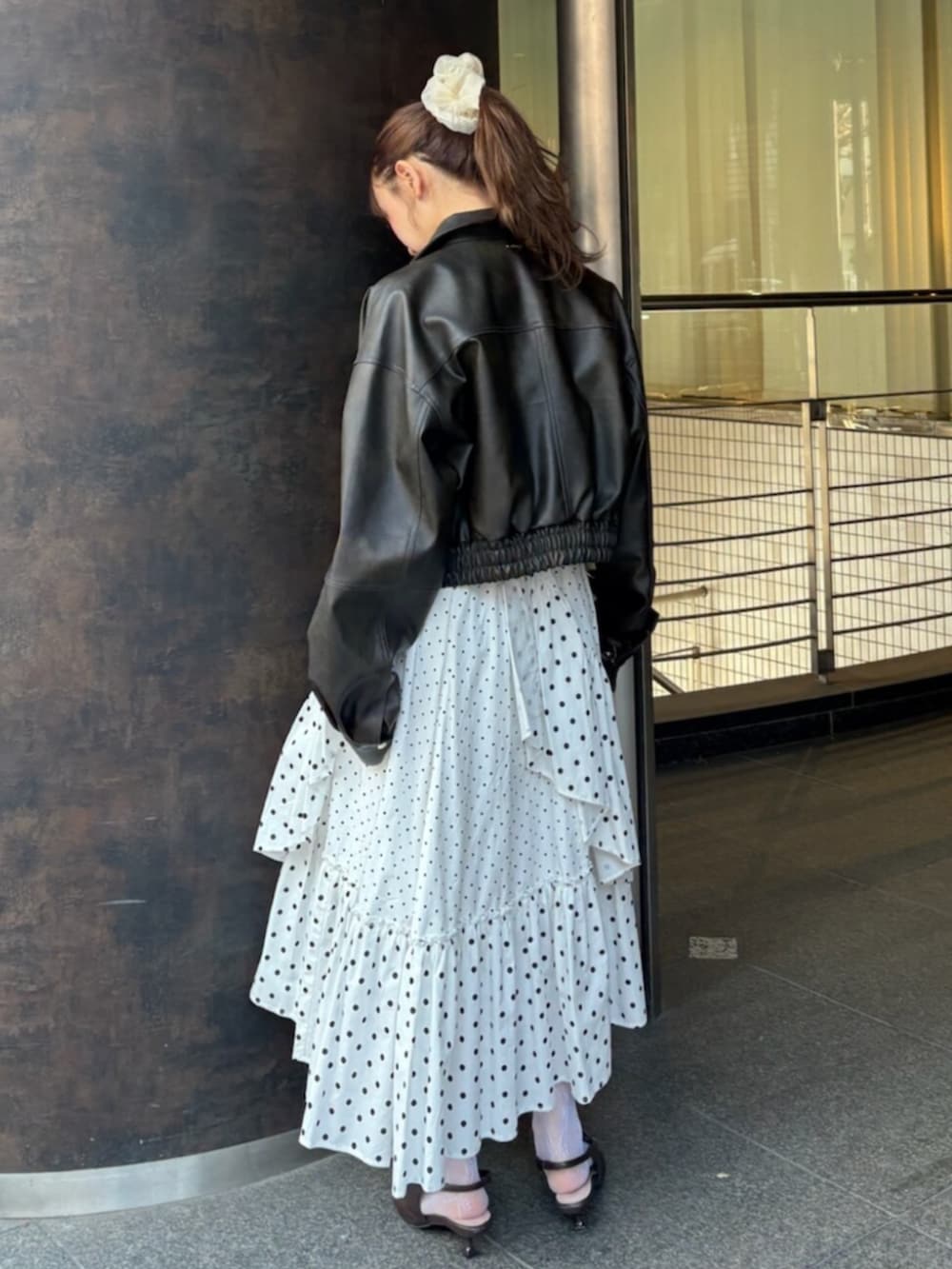 ブラウン系のブルゾン、ホワイト系のスカート、ブラウン系のサンダルを着用したレディースの冬コーディネートの3枚目の写真