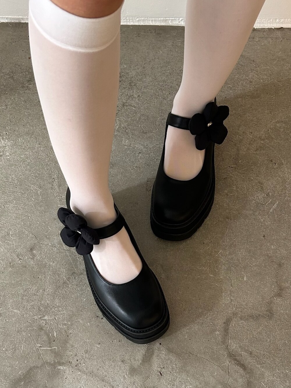 グレー系のスウェット、ホワイト系のローファー、ホワイト系のスカートを着用したレディースの秋コーディネートの6枚目の写真