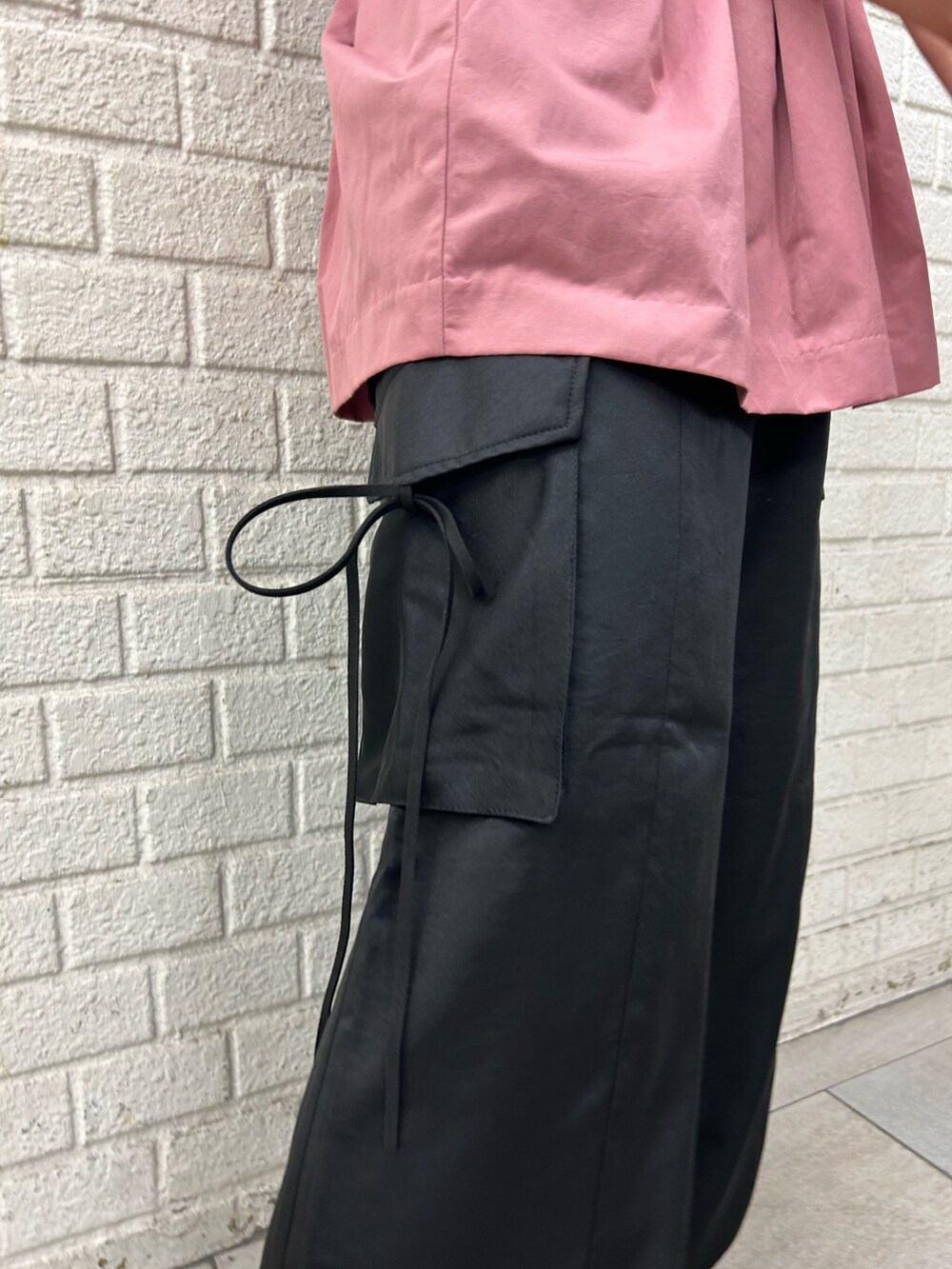 ブラック系のその他パンツ、ピンク系のTシャツ/カットソーを着用したレディースの夏コーディネートの6枚目の写真
