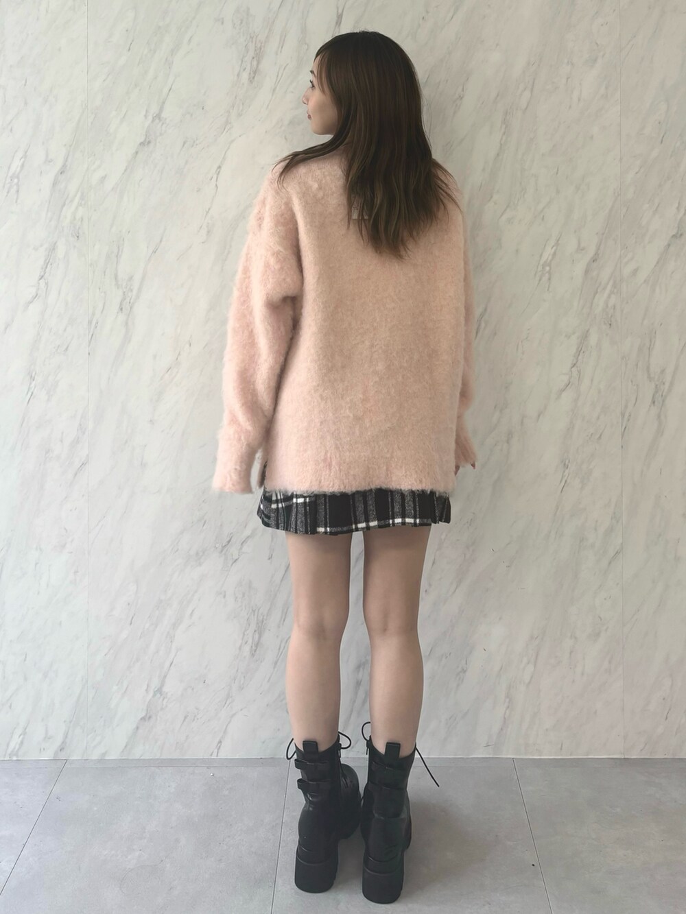 ホワイト系のニット/セーター、レッド系のスカート、ブラック系のブーツを着用したレディースの夏コーディネートの3枚目の写真