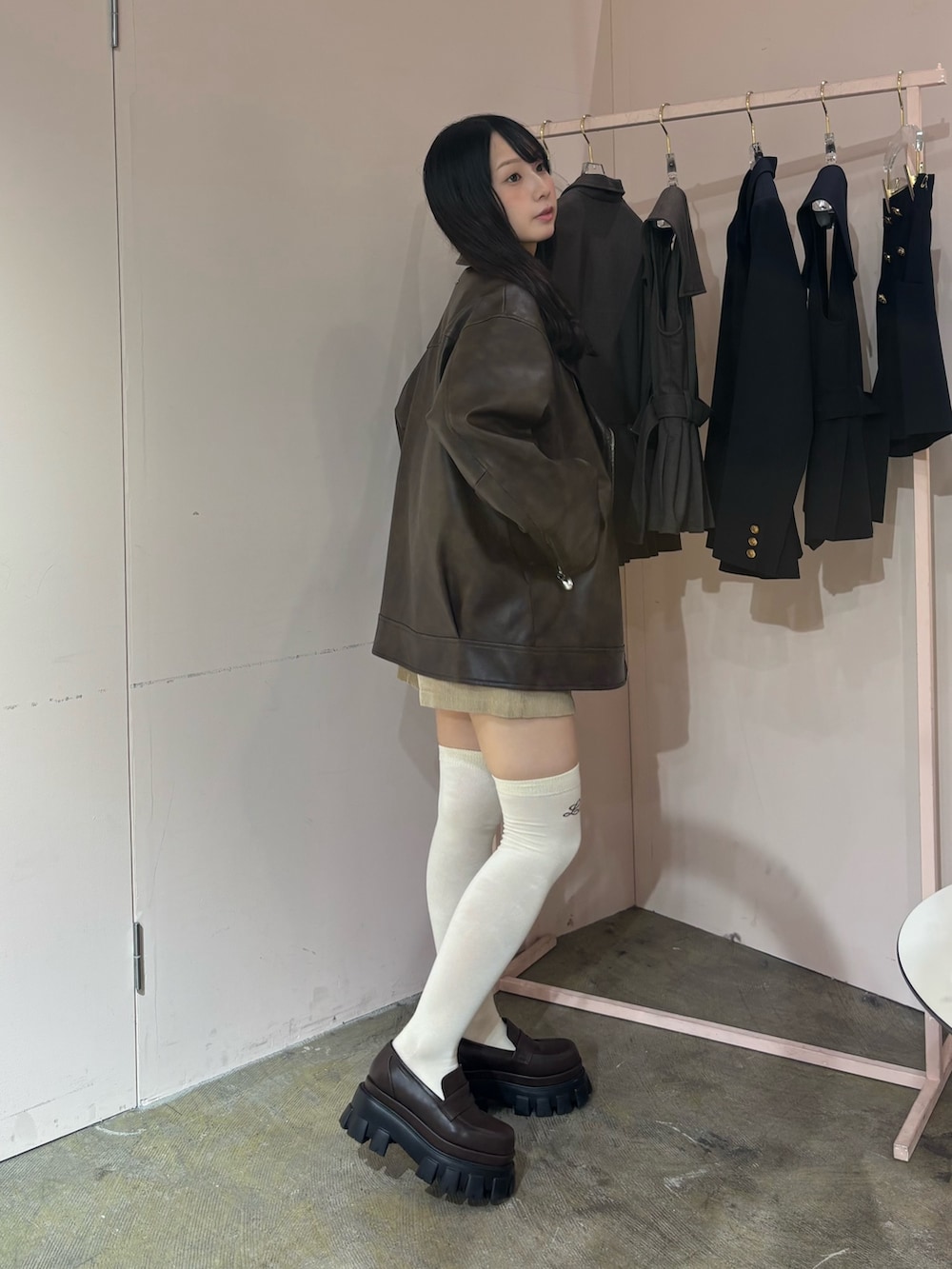 ブラウン系のライダースジャケット、ホワイト系のニット/セーター、ブラウン系のローファーを着用したレディースの秋コーディネートの3枚目の写真