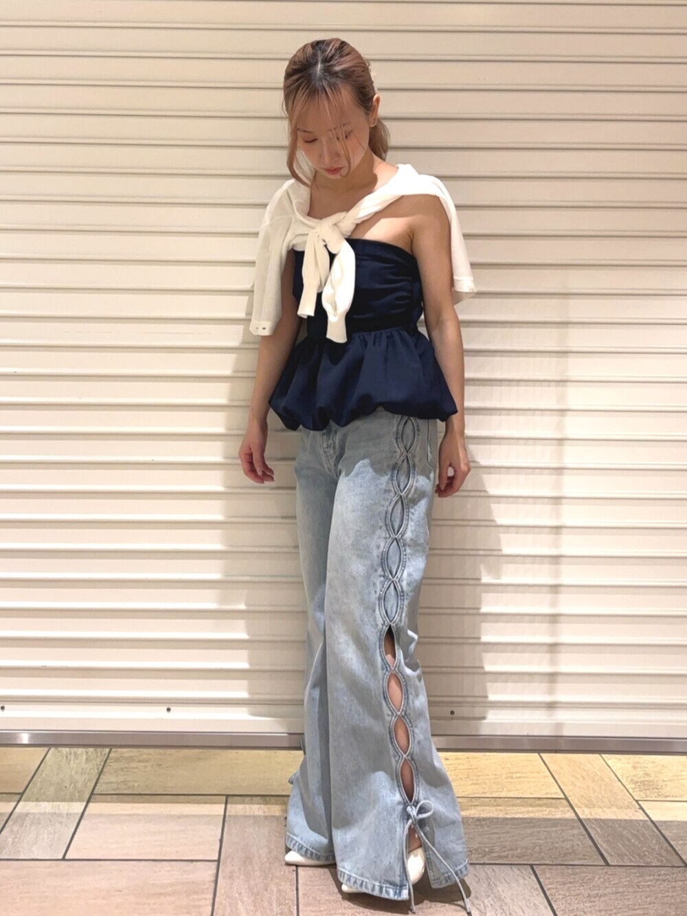 ホワイト系のカーディガン/ボレロ、ブルー系のデニムパンツ、ブルー系のチューブトップを着用したレディースの春コーディネートの6枚目の写真
