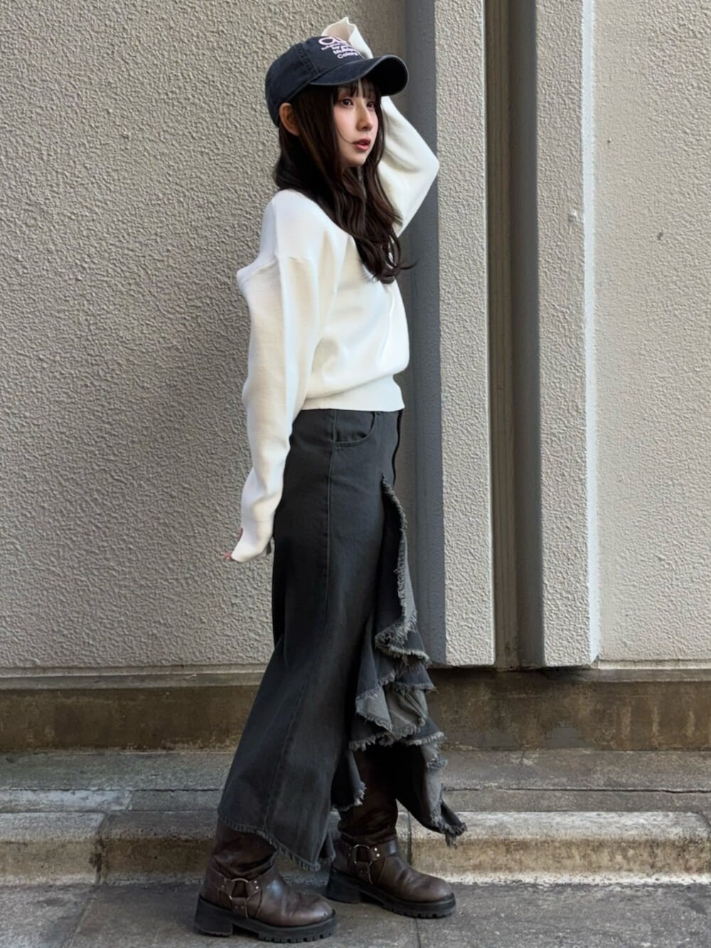 ホワイト系のニット/セーター、ブラック系のスカート、ブラック系のキャップを着用したレディースの冬コーディネートの2枚目の写真