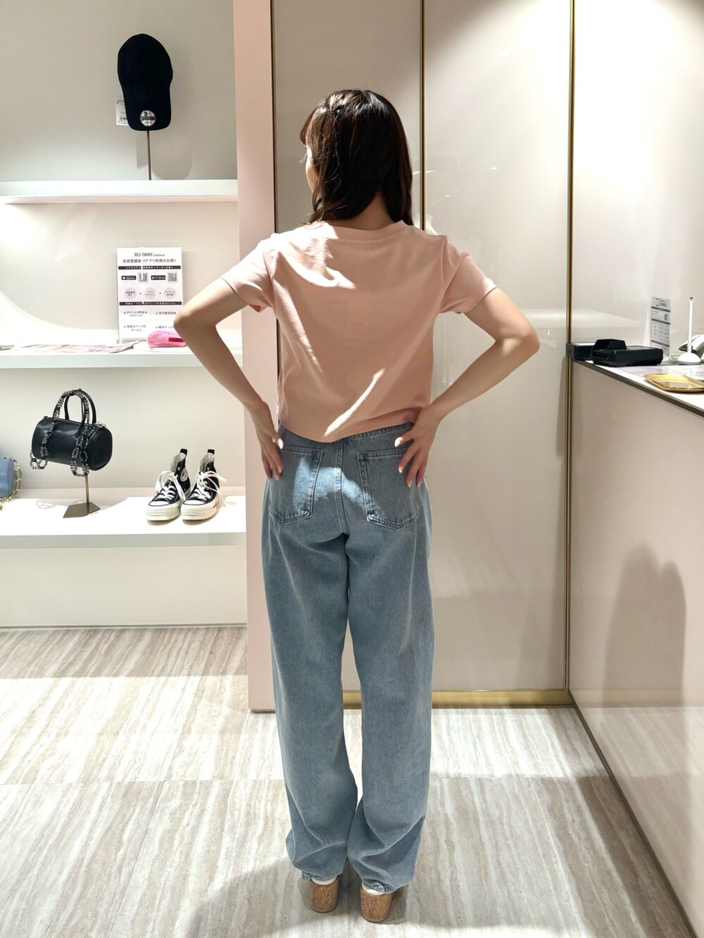 ブルー系のデニムパンツ、ピンク系のTシャツ/カットソー、イエロー系のサンダルを着用したレディースの春コーディネートの3枚目の写真